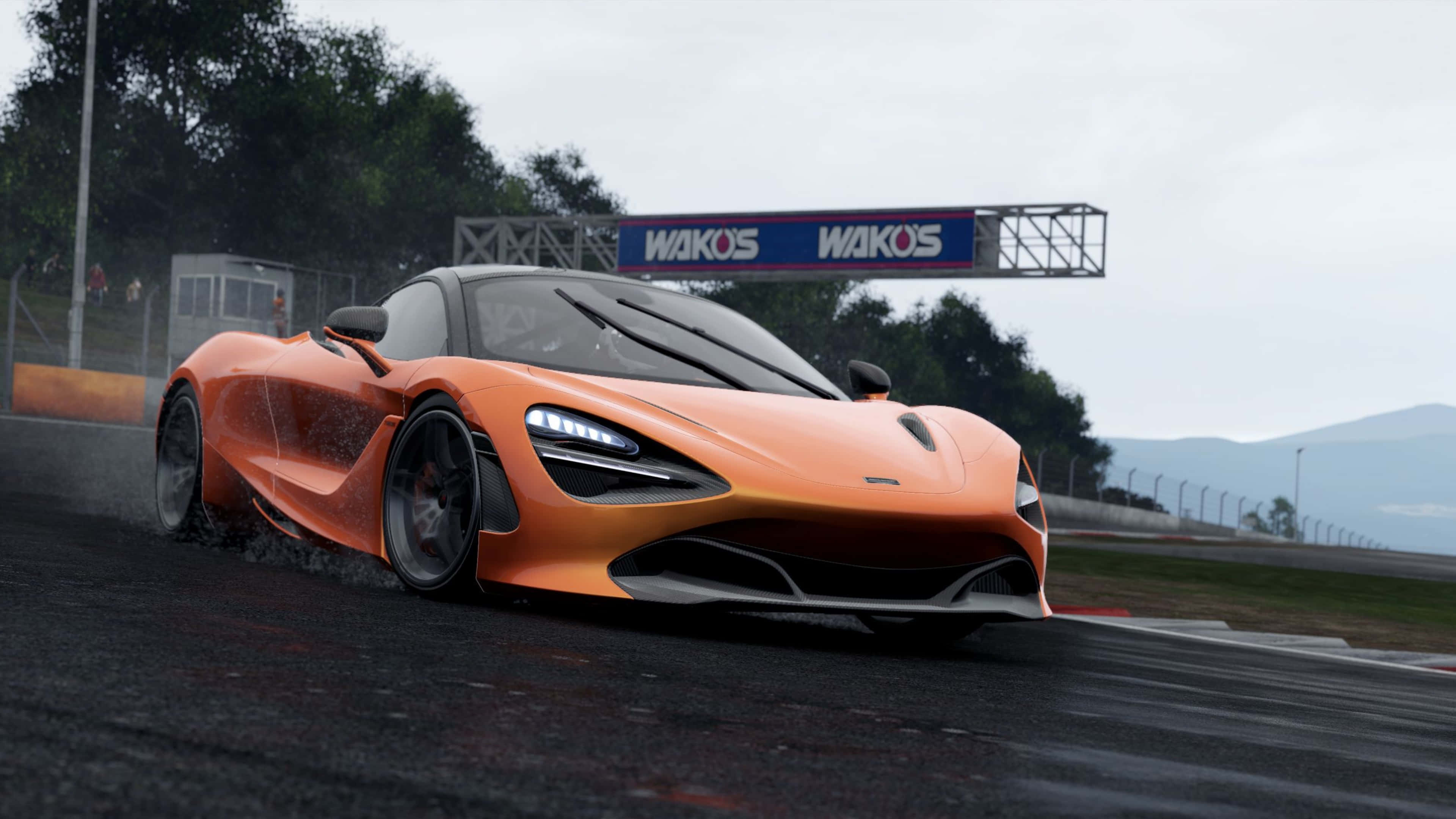 電玩遊戲 桌布 壁紙 — 一輛鮮橙色的McLaren 720S在多雲的天空下，於潮濕的賽道上飄移，遠方有山脈，上方有'WAKOS'標誌。