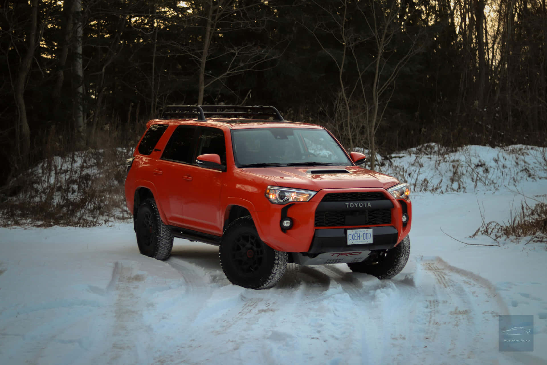 橙色豐田 4Runner 在黃昏時分行駛於積雪森林。 — Toyota Supra Mk4 壁紙