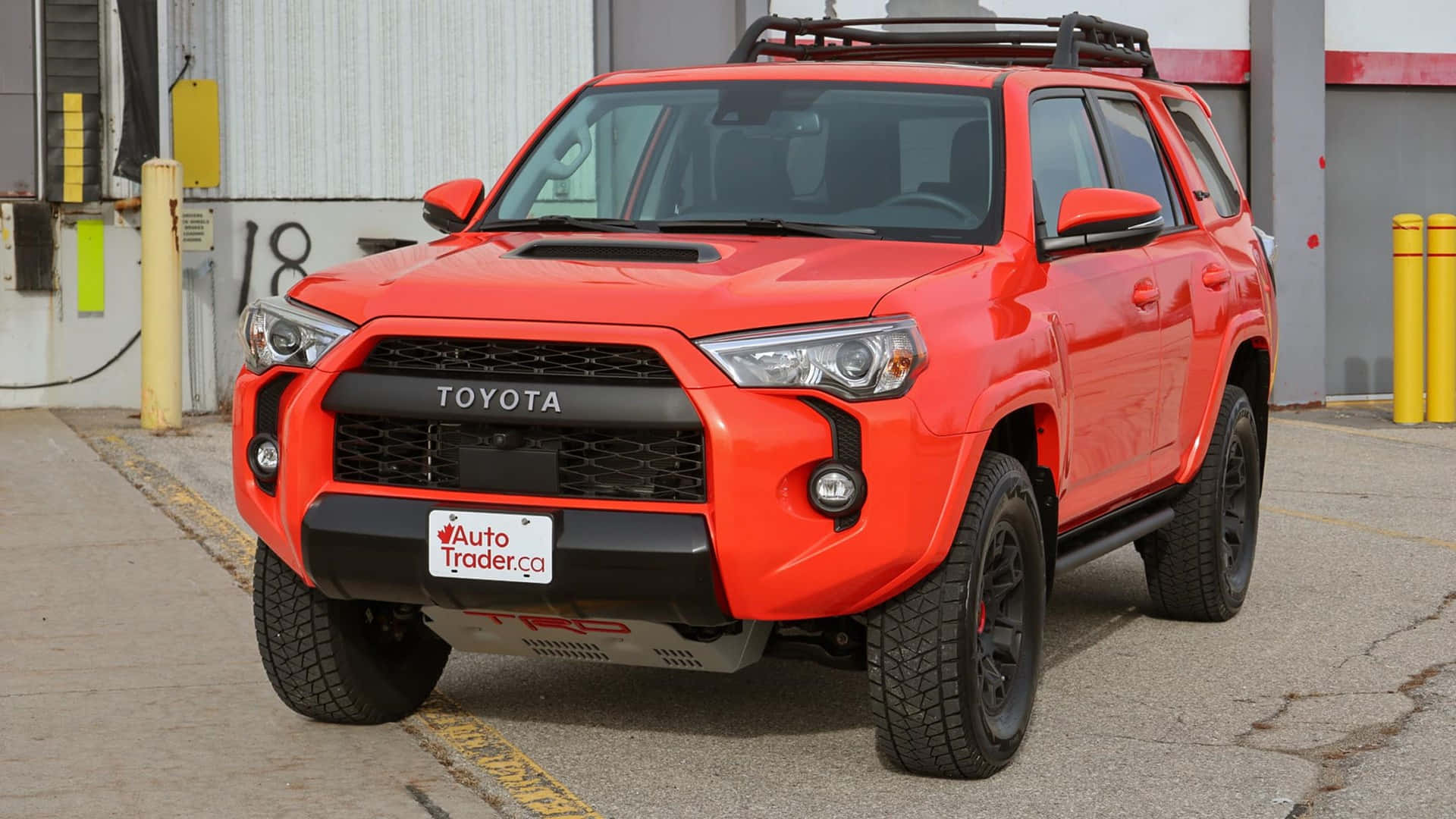 倉庫外停放的亮橙色豐田 4Runner TRD。 — Toyota Supra Mk4 壁紙