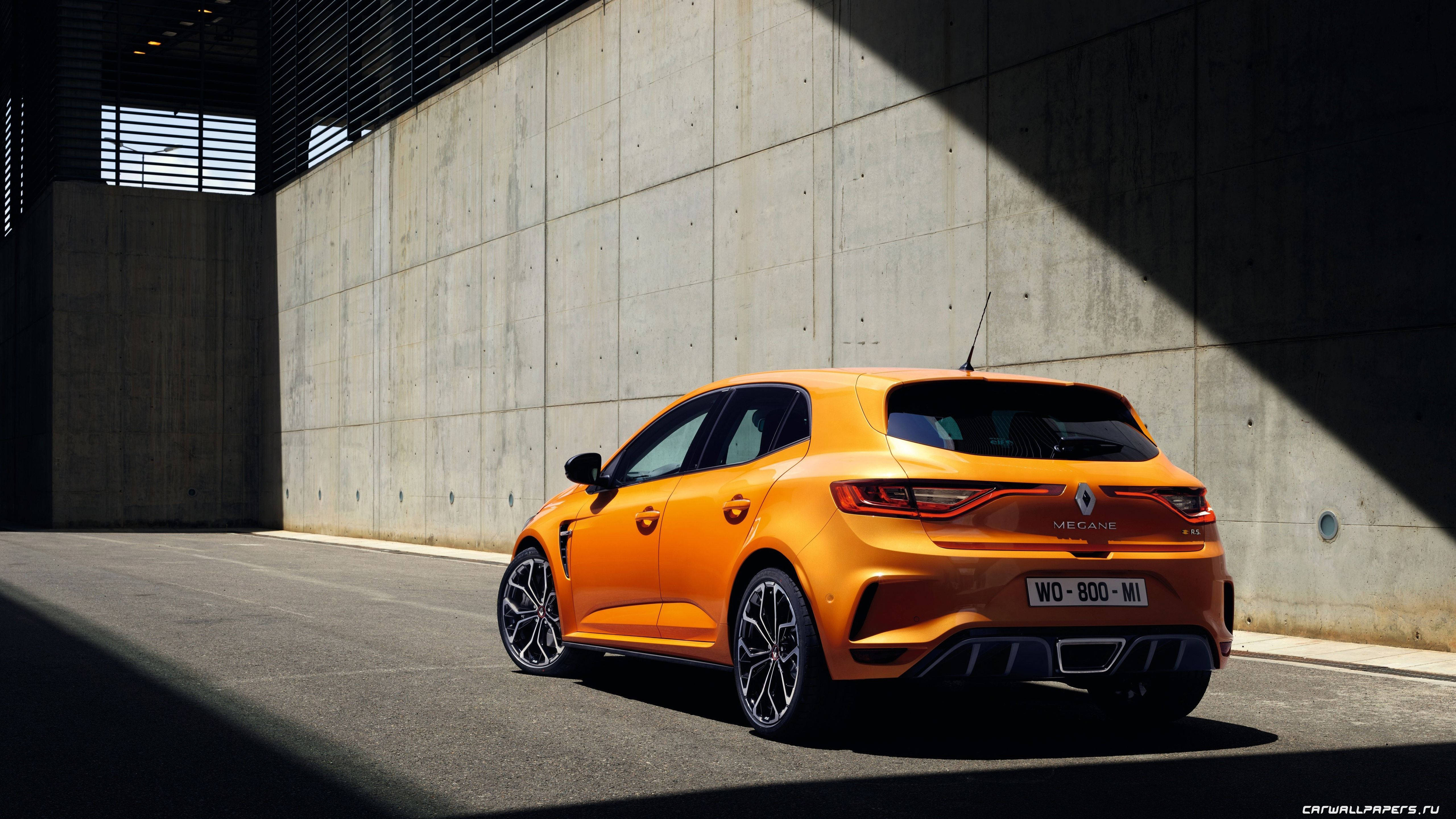 Renault 桌布 壁紙 — 一輛鮮橙色的雷諾 Mégane RS 停放在混凝土牆下，戲劇性的陽光投射出銳利的陰影。
