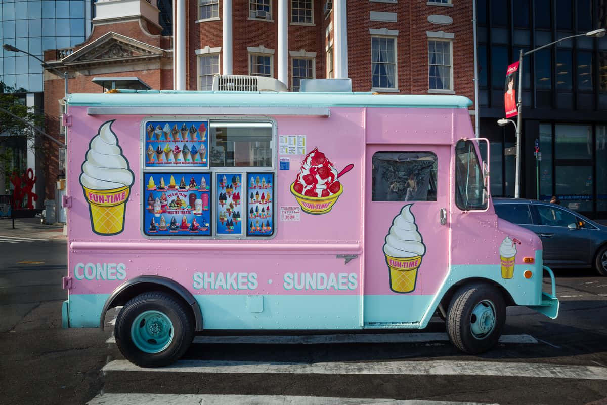 Ice Cream Truck 桌布 壁紙 — 一輛鮮粉紅色和青綠色的冰淇淋車停在城市街道上，帶有色彩繽紛的甜點圖案和現代建築背景。