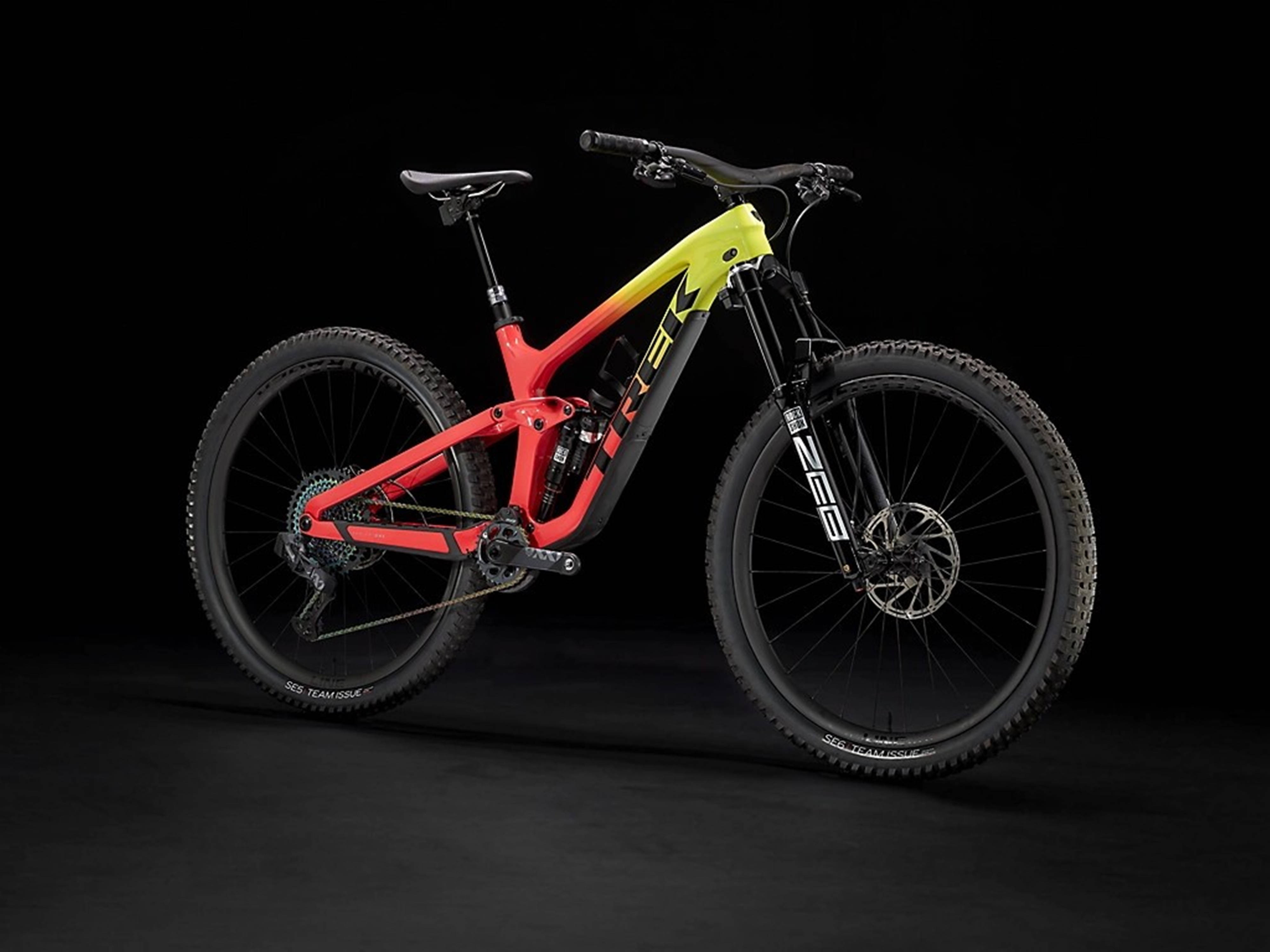 Mountain Bike 桌布 壁紙 — 一輛鮮紅與黃色的全避震登山車，搭配黑色輪胎，矗立在純黑攝影棚背景前。