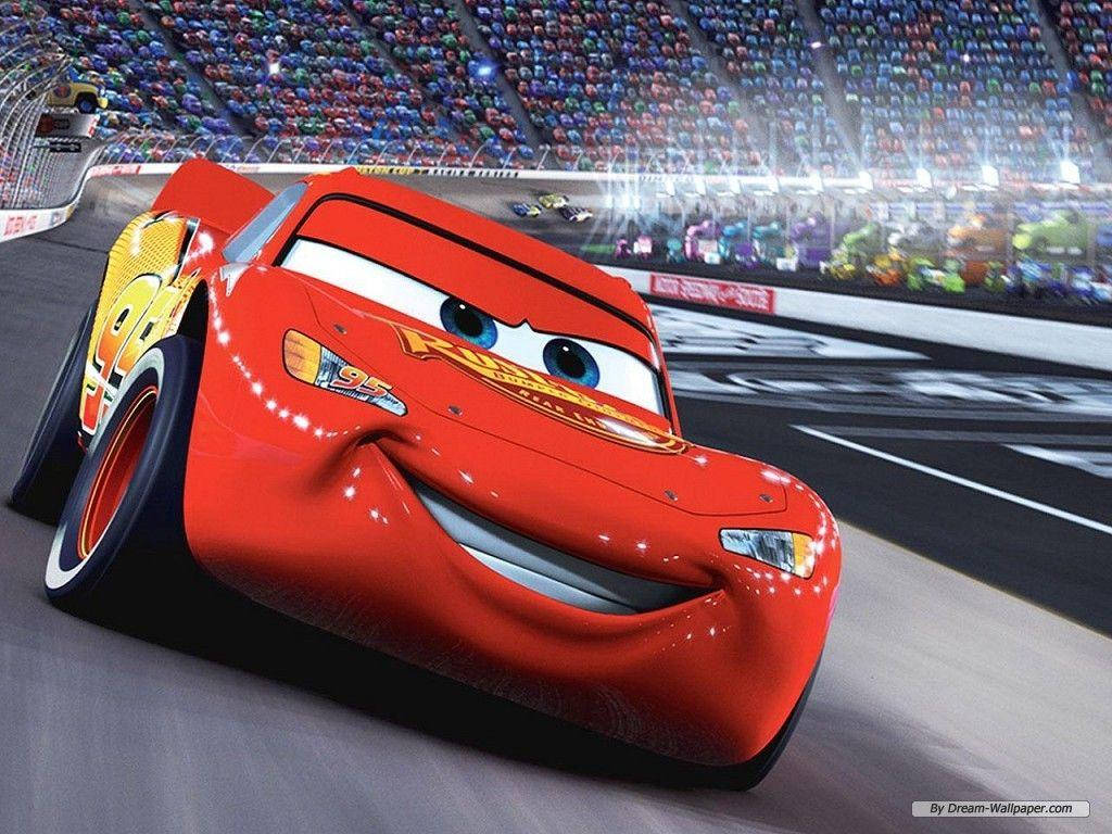 Lightning Mcqueen 桌布 壁紙 — 一輛鮮紅色、面帶微笑的動畫賽車在體育館燈光下沿著賽道飛馳，周圍是歡呼的人群。