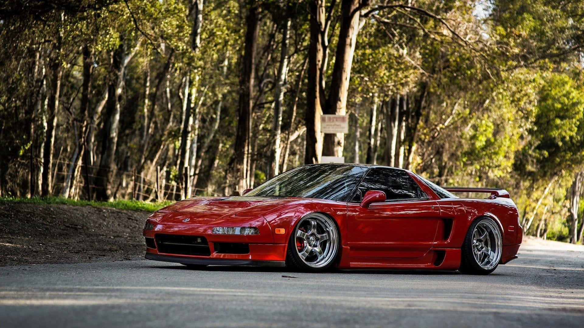 Acura Nsx 桌布 壁紙 — 一輛鮮紅色改裝跑車停泊在森林道路上，沐浴在穿過高聳樹木的金色陽光中。