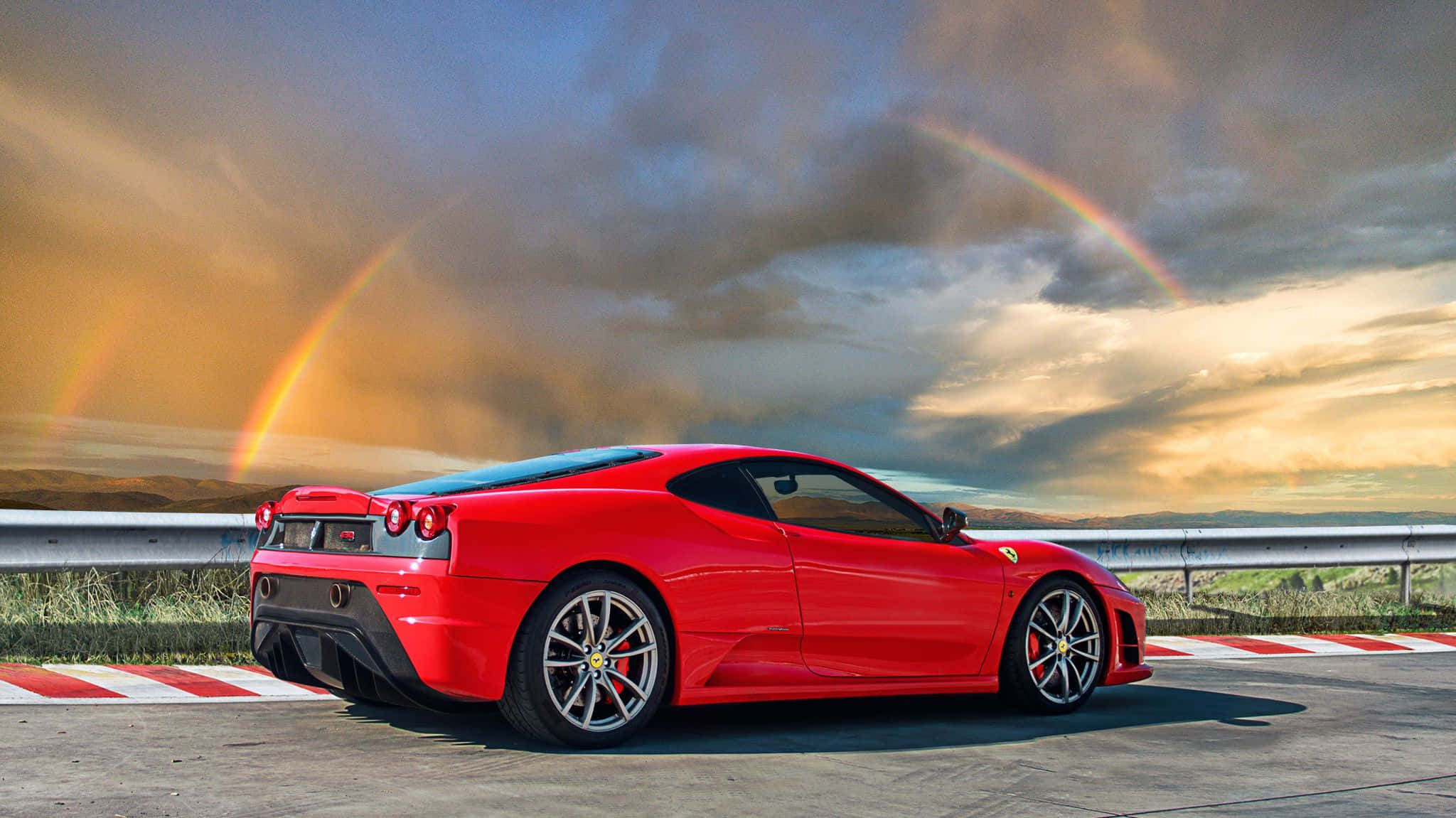 Ferrari F430 桌布 壁紙 — 一輛鮮紅色法拉利跑車停放在賽道上，天空戲劇性，一道鮮明的雙彩虹拱起在上方。