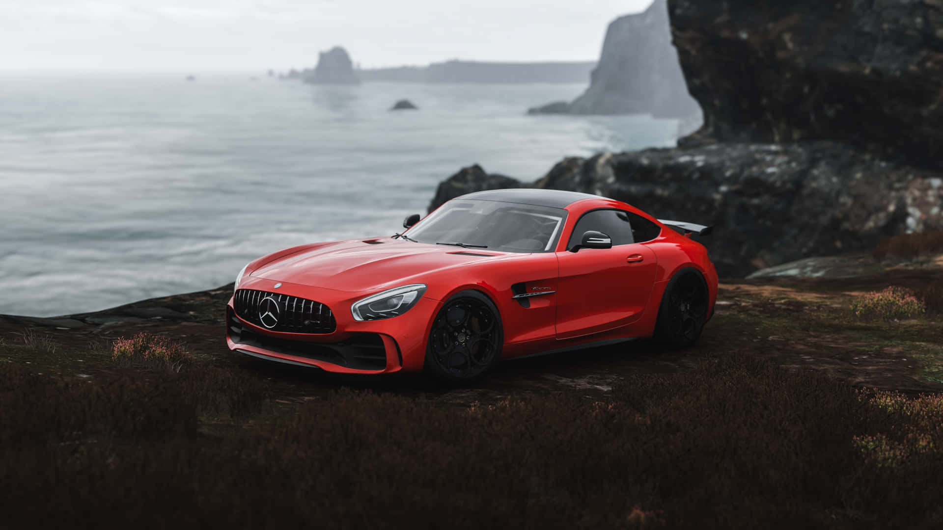 汽車 桌布 壁紙 — 一輛鮮紅色的 Mercedes-AMG GT 停泊在霧氣瀰漫的懸崖上，俯瞰著平靜的海洋和崎嶇的岩石。