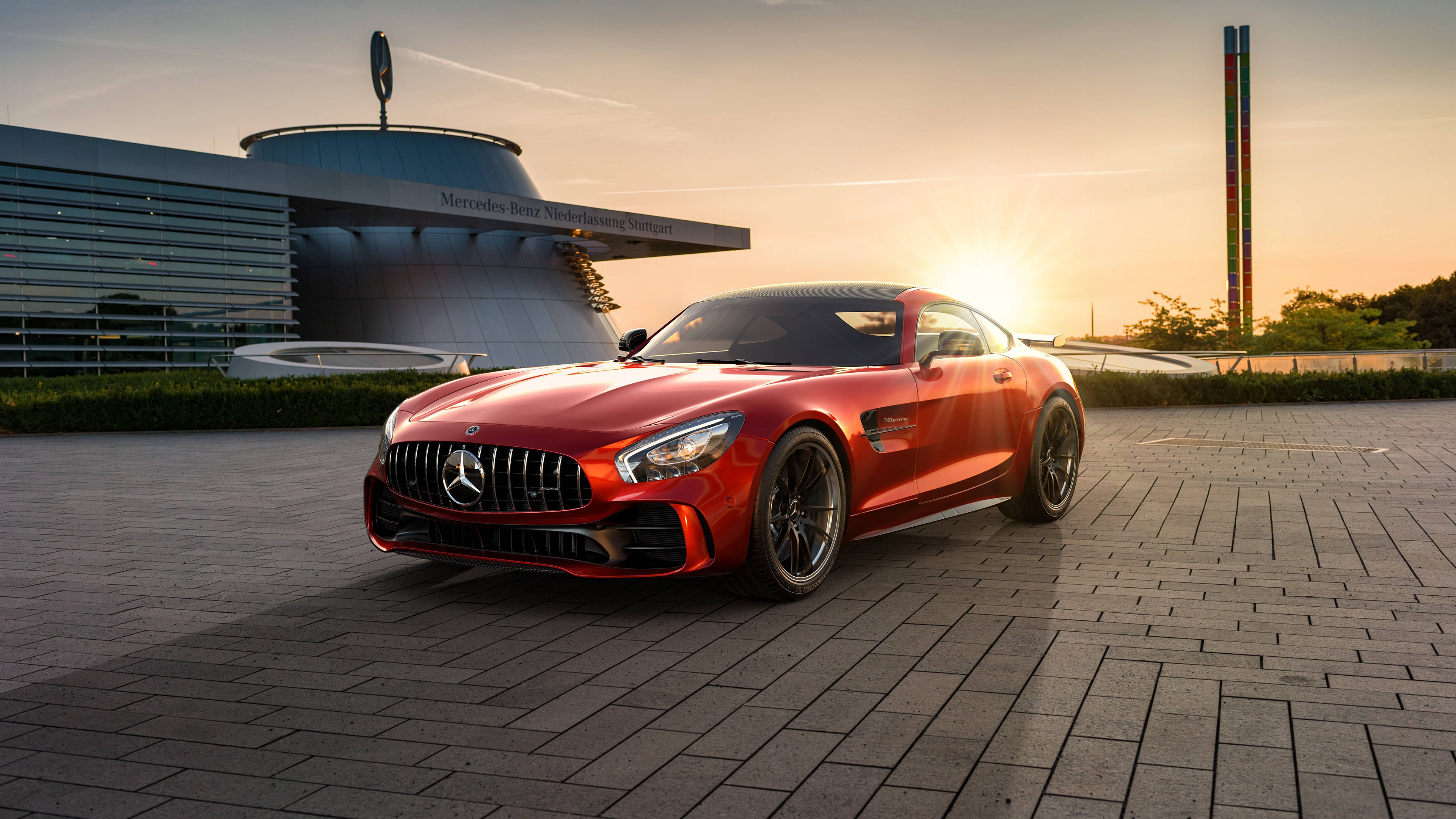 Gtr 桌布 壁紙 — 一輛鮮紅色的 Mercedes-AMG GT 跑車在日落時分閃耀於鋪砌的廣場上，背景是 Mercedes-Benz 博物館。