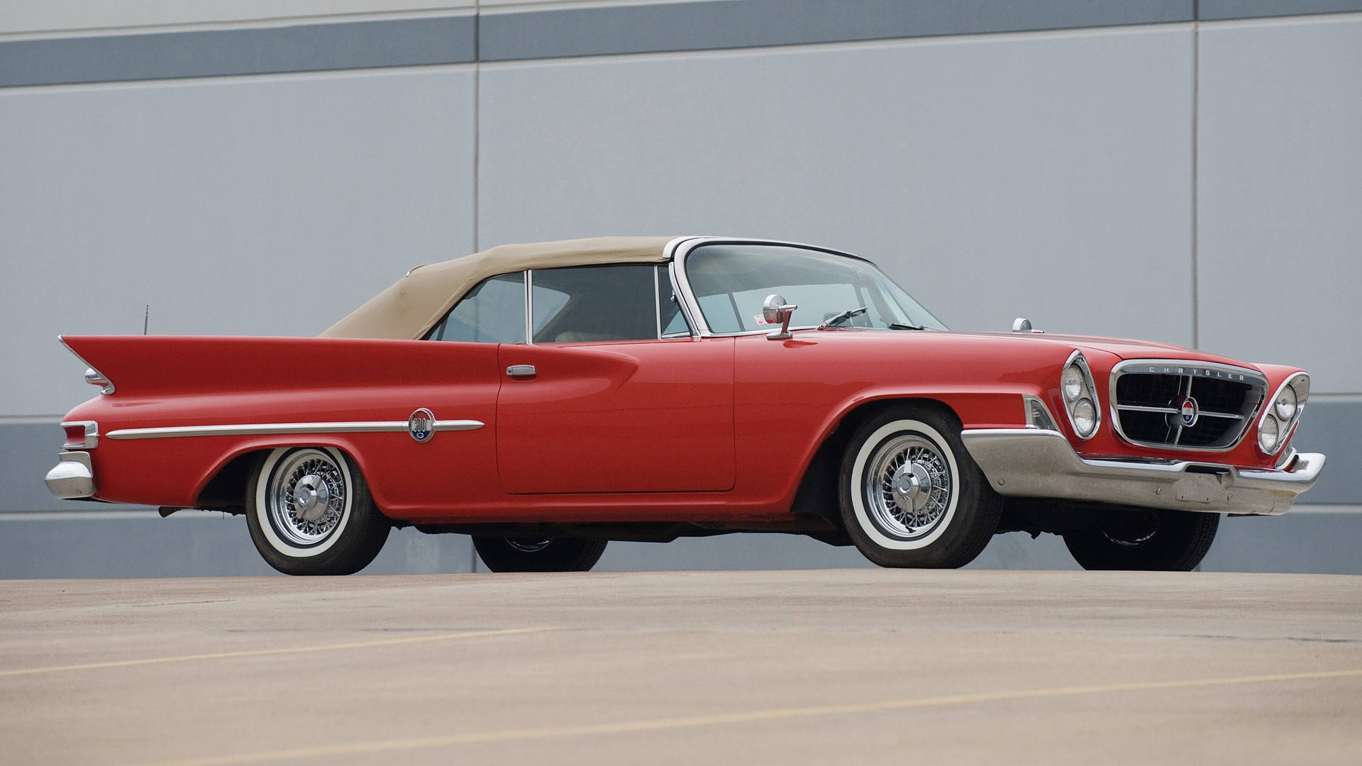 Chrysler 桌布 壁紙 — 一輛鮮紅色的1950年代敞篷車，配備棕褐色軟頂，停放在現代灰色牆壁旁。