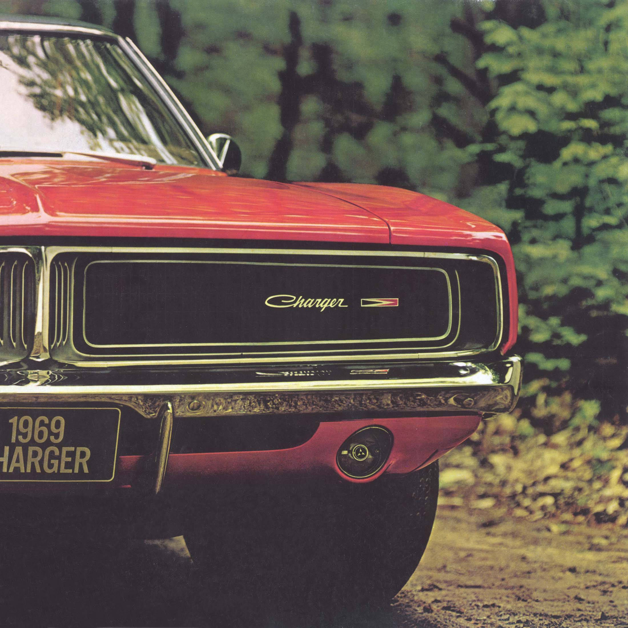 Charger 桌布 壁紙 — 一輛鮮紅色的1969年道奇Charger，帶有鍍鉻格柵和引擎蓋標誌，停在綠樹成蔭的泥路上。