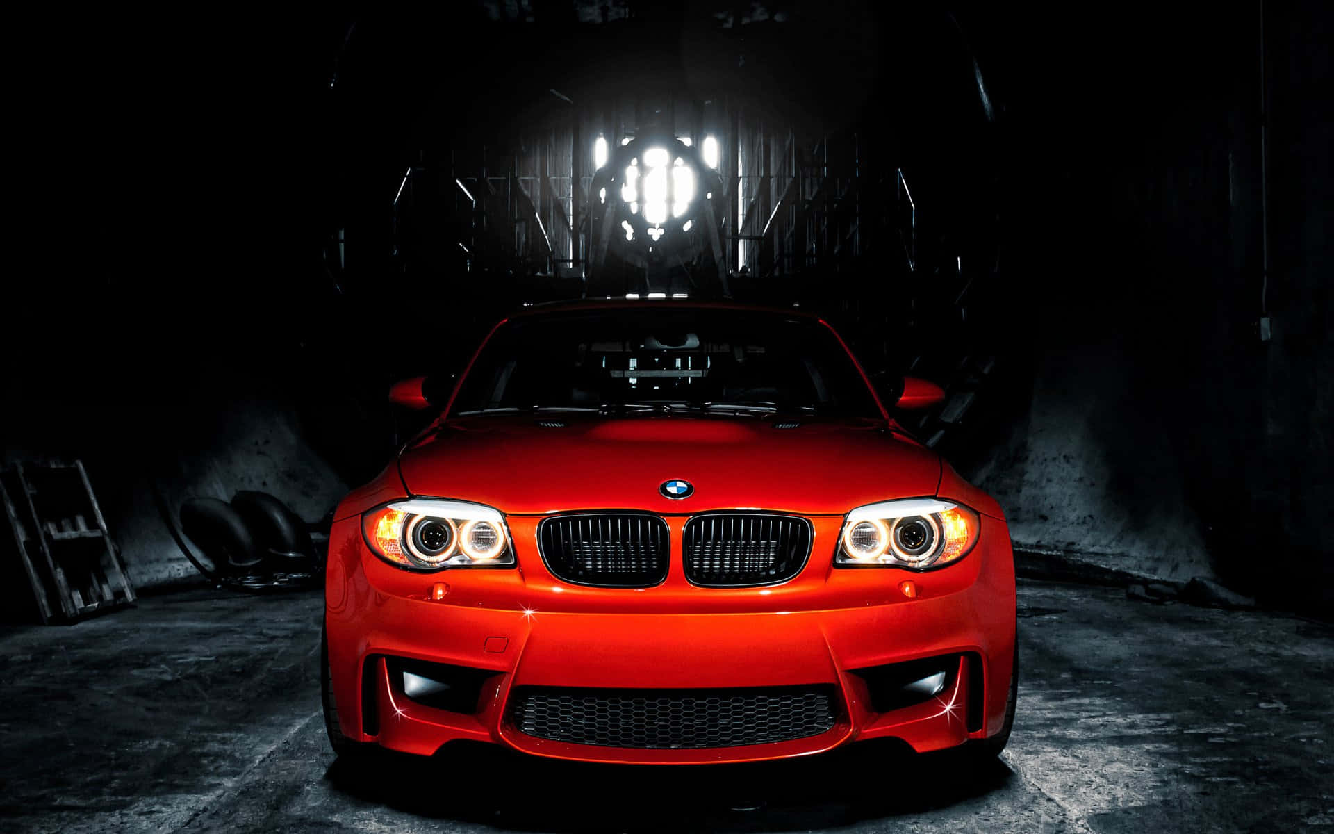 Bmw M Series 桌布 壁紙 — 一輛鮮紅色的BMW跑車在黑暗的工業車庫中，在戲劇性的聚光燈下閃耀。