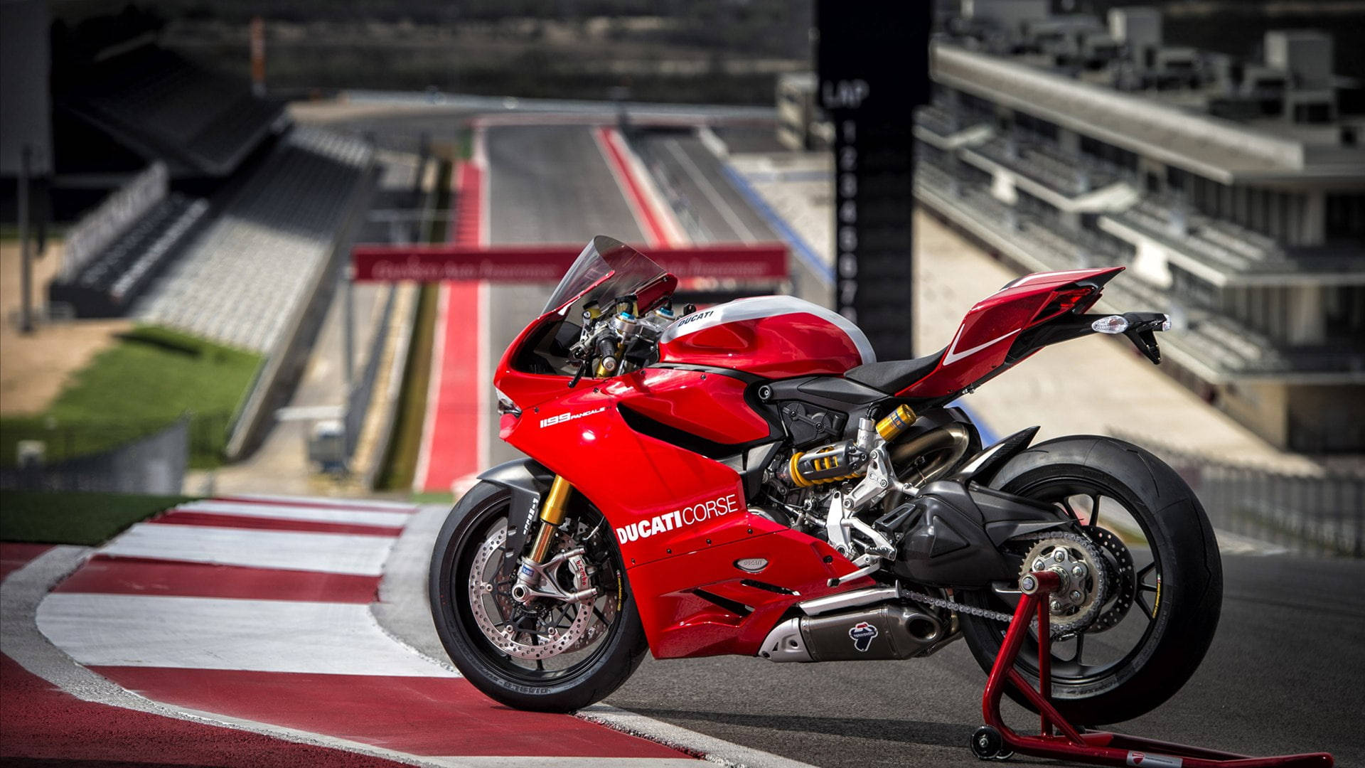 杜卡迪 桌布 壁紙 — 一輛鮮紅色的Ducati Corse摩托車在賽道彎道處蓄勢待發，背景有觀眾席。