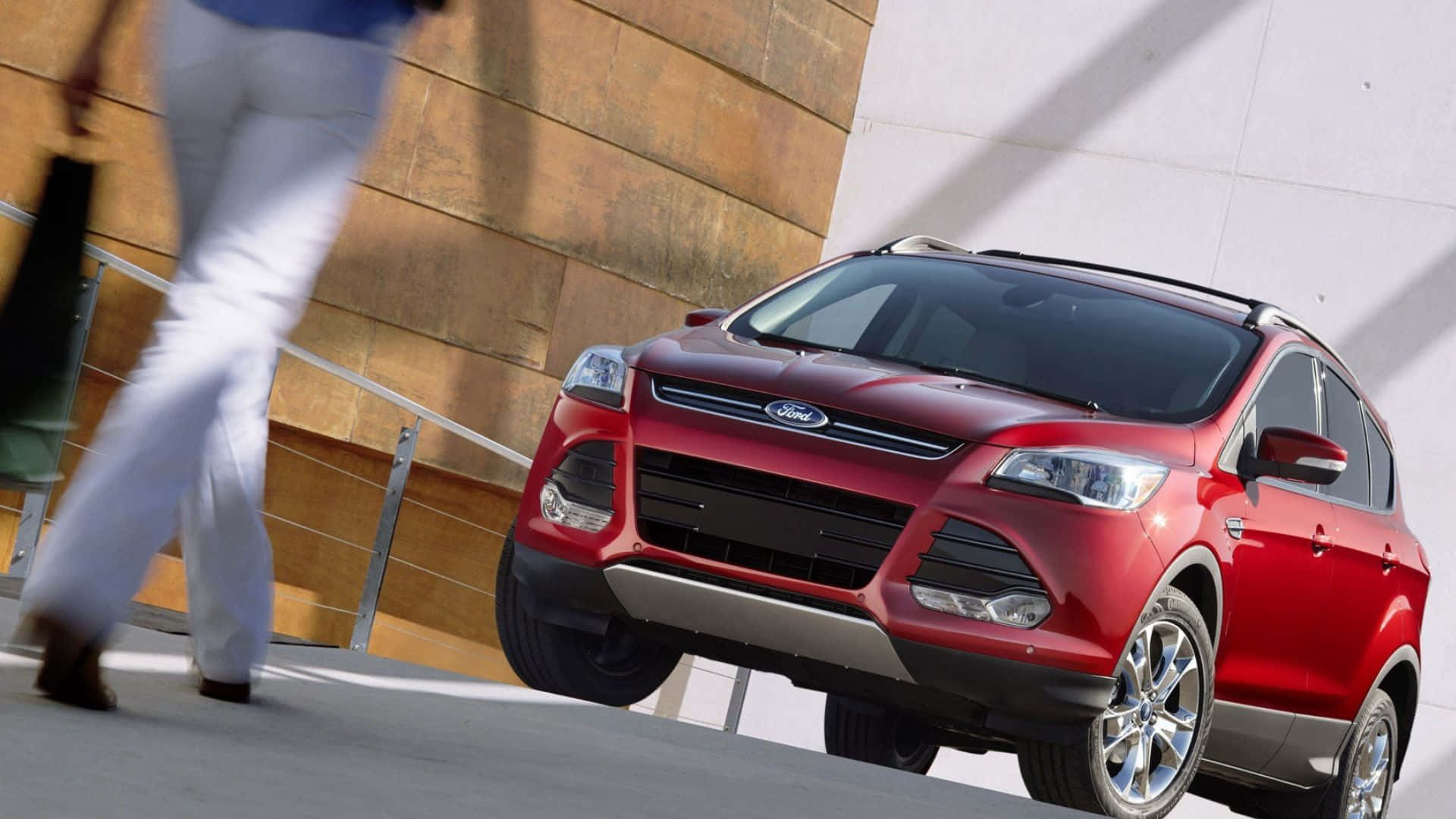 Ford Escape 桌布 壁紙 — 一輛鮮紅色的Ford Escape SUV停在一棟現代建築旁邊，有一個模糊的行人走過。