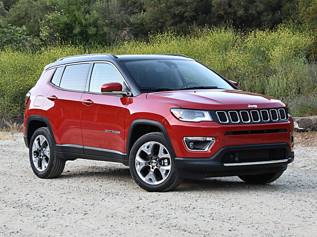 汽車 桌布 壁紙 — 一輛鮮紅色的Jeep Compass SUV停放在碎石上，背景有綠色灌木和樹木。