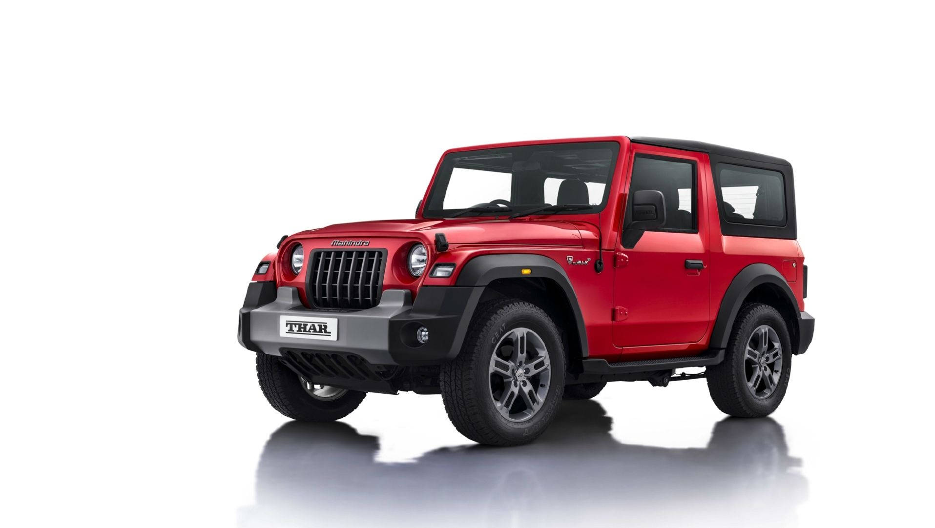 高清 桌布 壁紙 — 一輛鮮紅色的Mahindra Thar SUV在潔白的攝影棚背景前，帶有微妙的倒影，顯得霸氣十足。