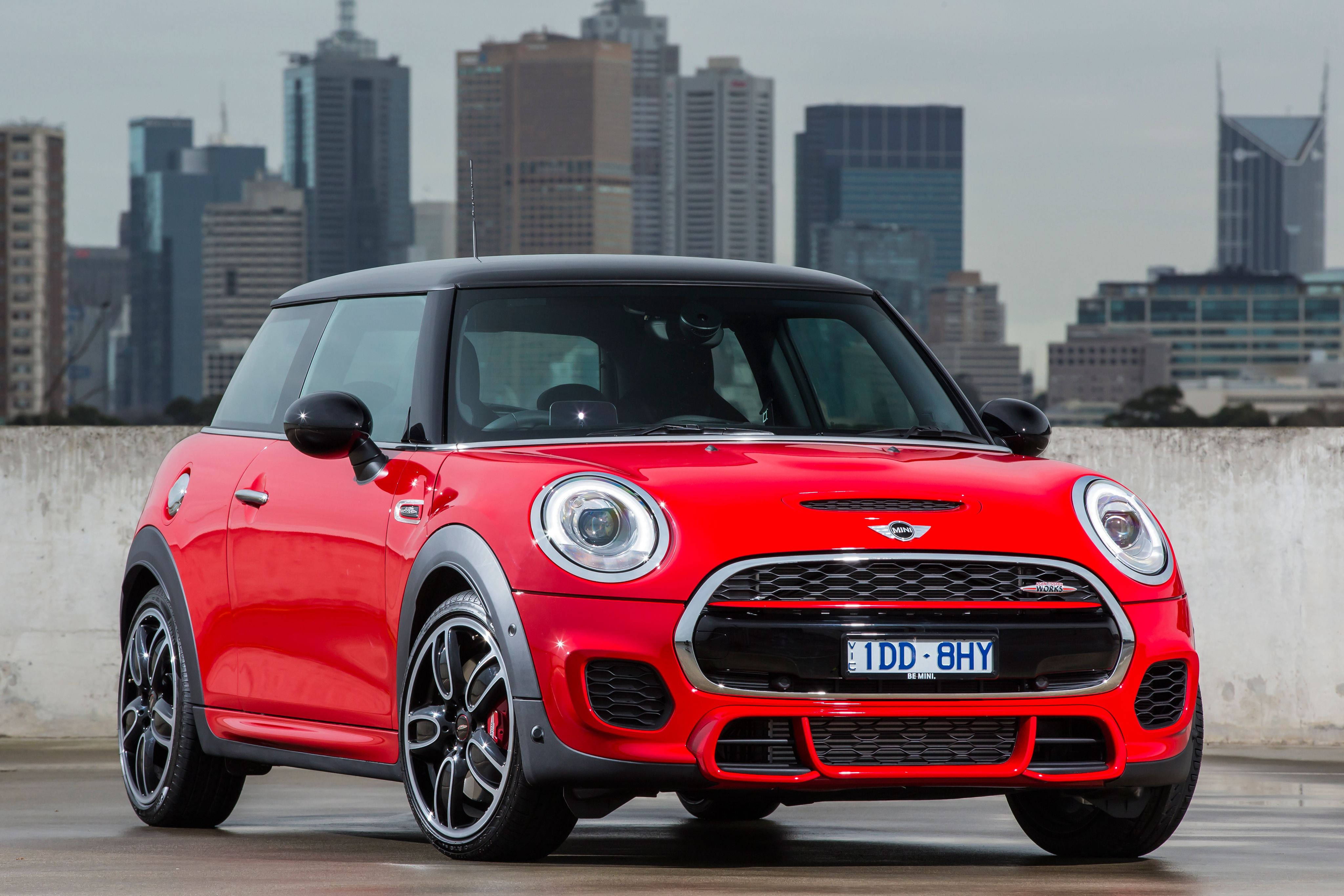 Mini Cooper 桌布 壁紙 — 一輛鮮紅色的MINI Cooper S停放在屋頂上，背景是現代城市天際線。