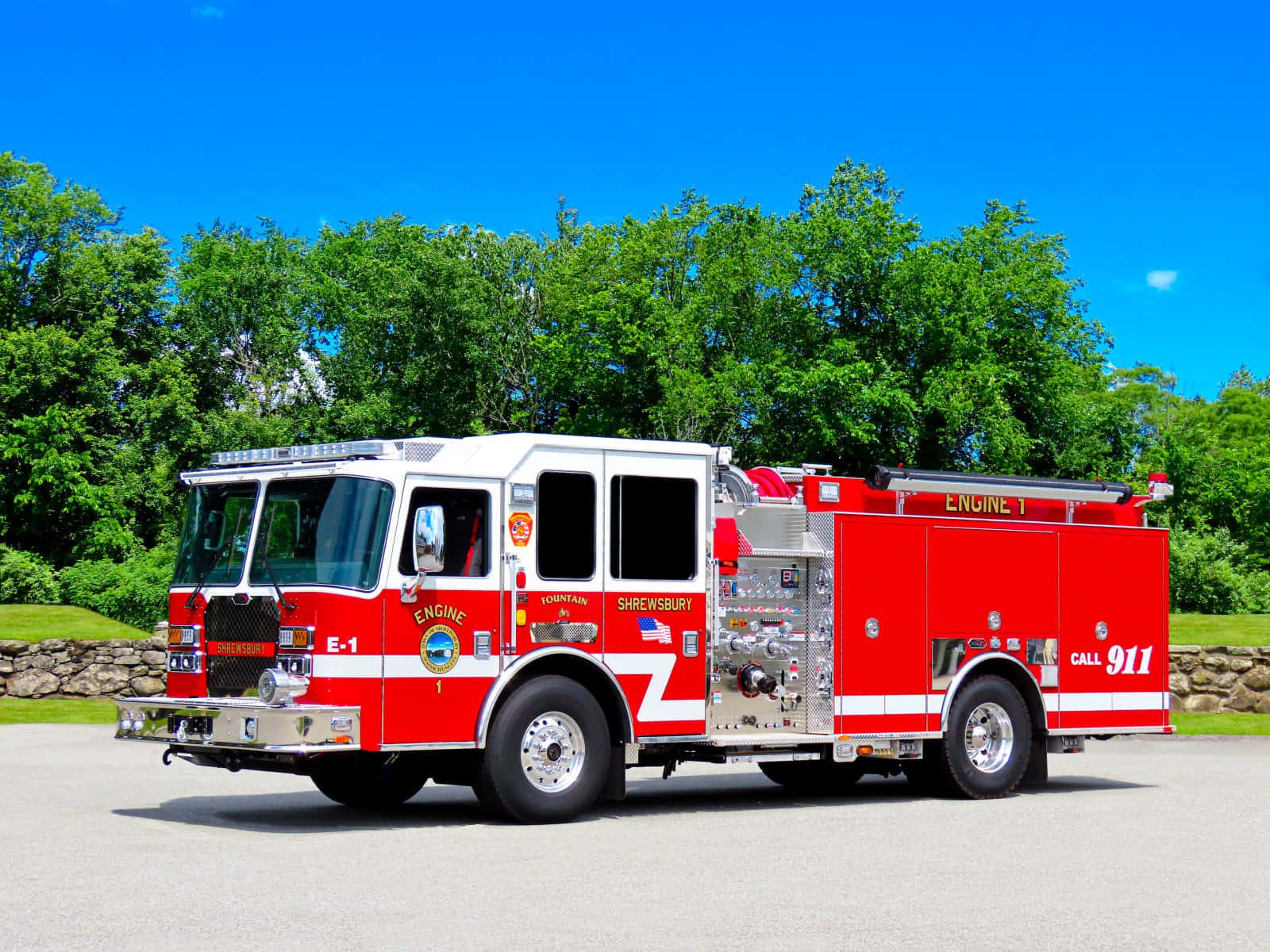 Fire Truck 桌布 壁紙 — 一輛鮮紅色的Shrewsbury Engine 1消防車停在柏油路上，天空清澈湛藍，背後是茂密的綠樹。