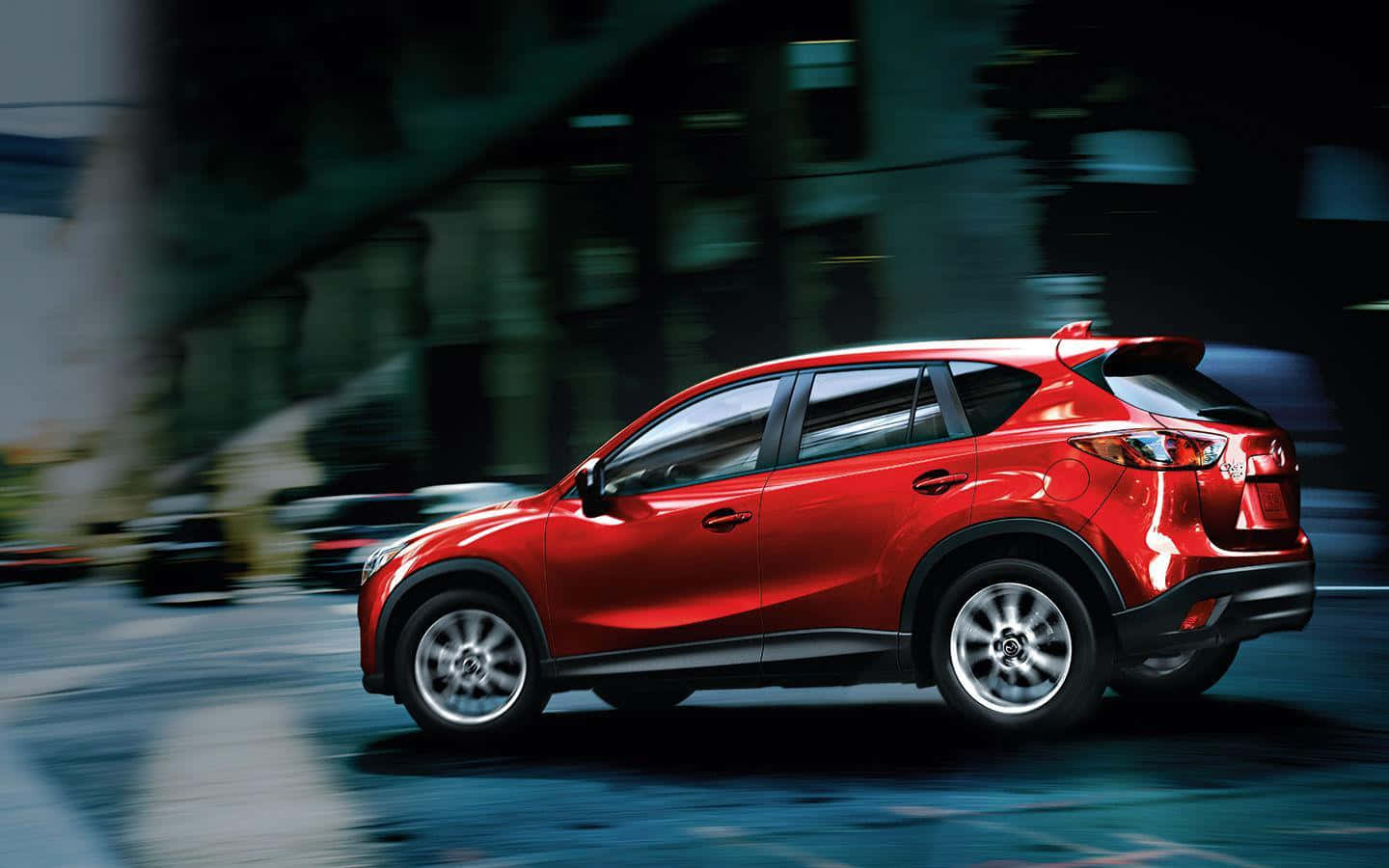 Mazda Cx-5 桌布 壁紙 — 一輛鮮紅色的SUV在夜間穿過模糊的城市街道，動態模糊強調了其動態移動。