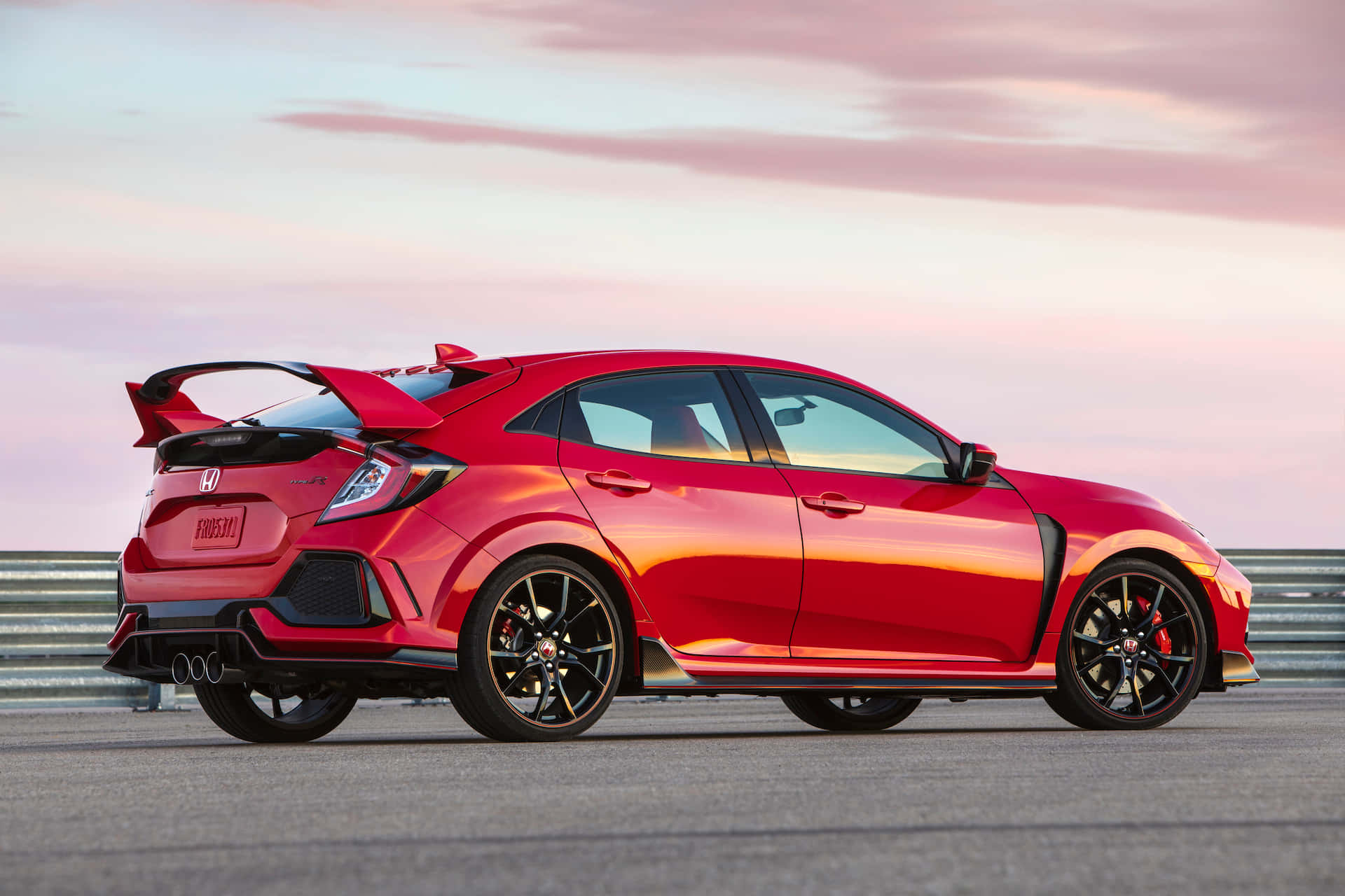 Honda Civic 桌布 壁紙 — 一輛鮮紅色的本田思域Type R跑車在日落時分的賽道上閃耀，天空呈現粉紅色和橙色。