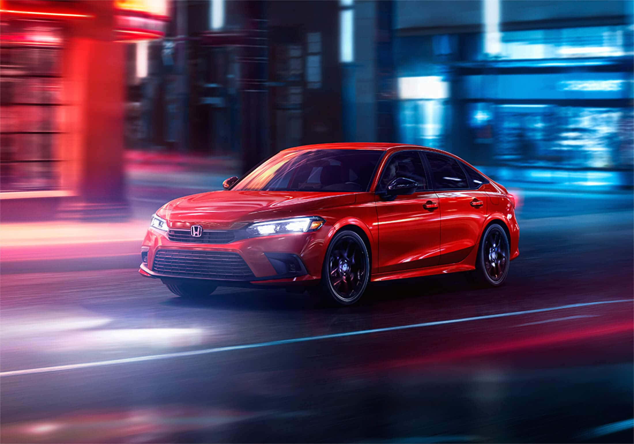 Honda Civic 桌布 壁紙 — 一輛鮮紅色的本田轎車在夜晚穿過霓虹燈閃爍的城市街道，帶有紅色和藍色燈光的動態模糊痕跡。
