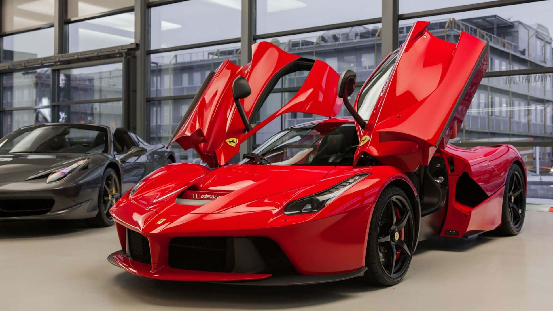 Ferrari Laferrari 桌布 壁紙 — 一輛鮮紅色的法拉利 LaFerrari 打開鷗翼車門，自豪地停放在現代化的玻璃牆展廳中。