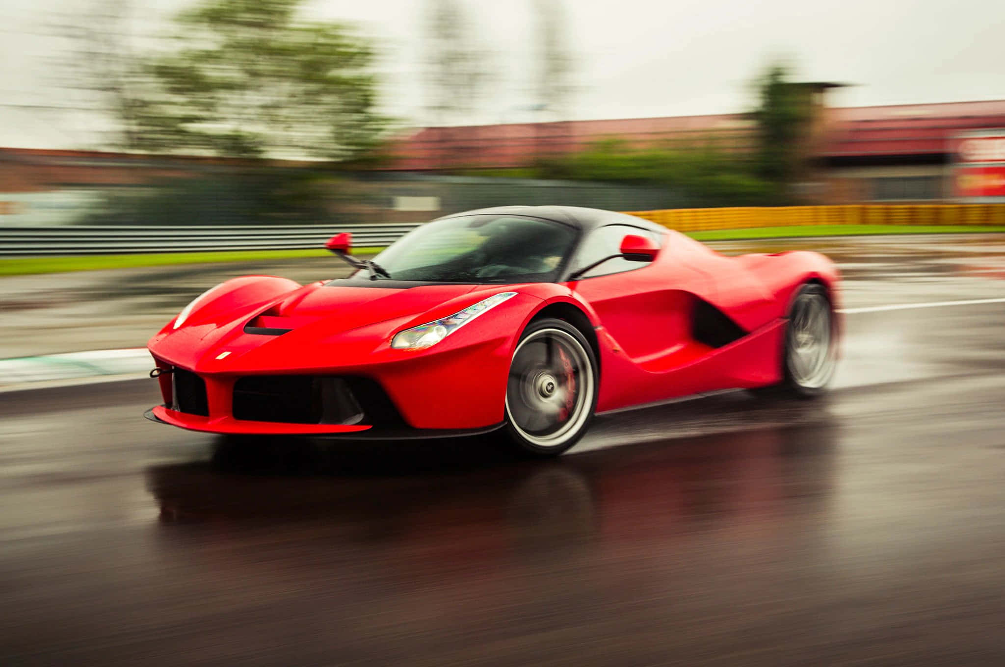 法拉利 桌布 壁紙 — 一輛鮮紅色的法拉利 LaFerrari 在潮濕的賽道上高速行駛，動態模糊傳達出極高速度。