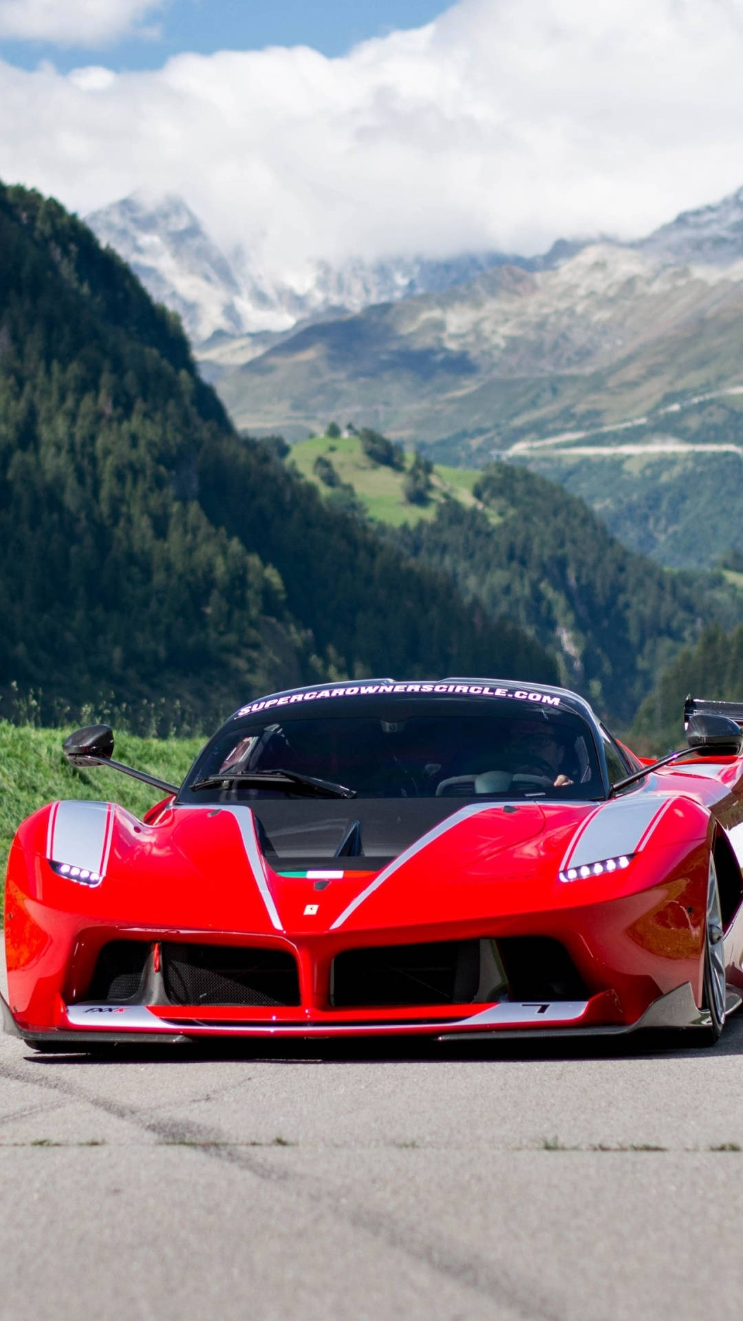 跑車 桌布 壁紙 — 一輛鮮紅色的法拉利 LaFerrari 停在山路上，背景是白雪覆蓋的山峰和翠綠的森林。