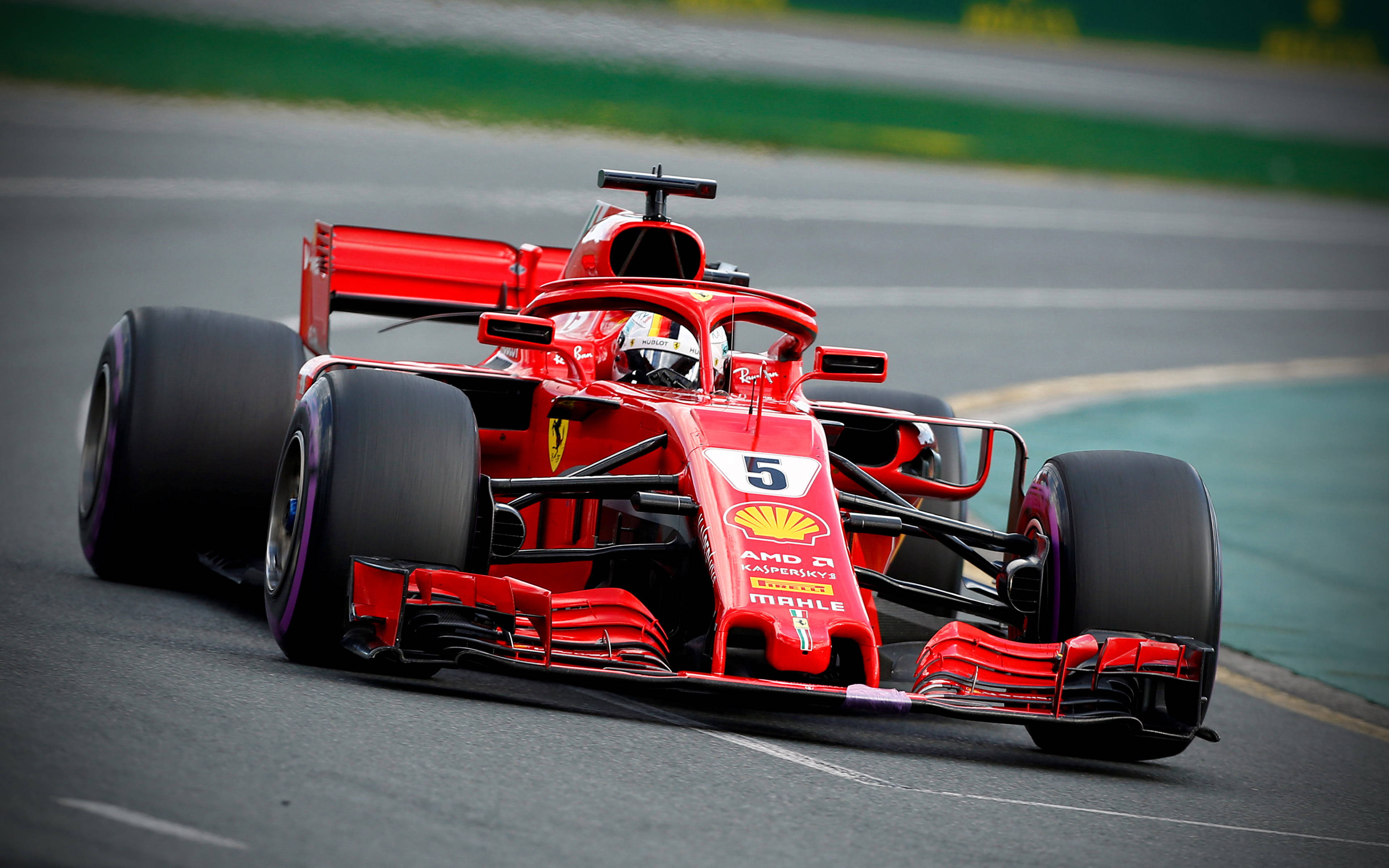 ferrari f1 2018 桌布 壁紙 — 一輛鮮紅色的法拉利F1賽車（編號5）在濕滑的賽道上奔馳，背景是綠草如茵。