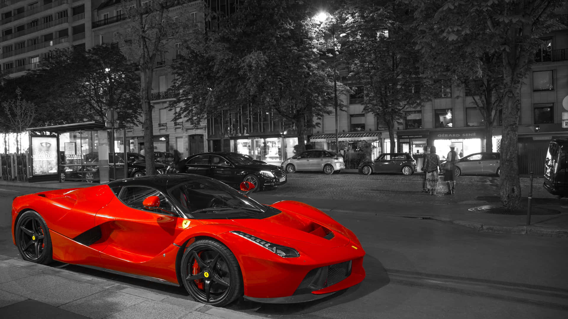 一輛紅色法拉利LaFerrari停在夜晚的城市街道上，有行人經過。 — 法拉利 GIF 壁紙