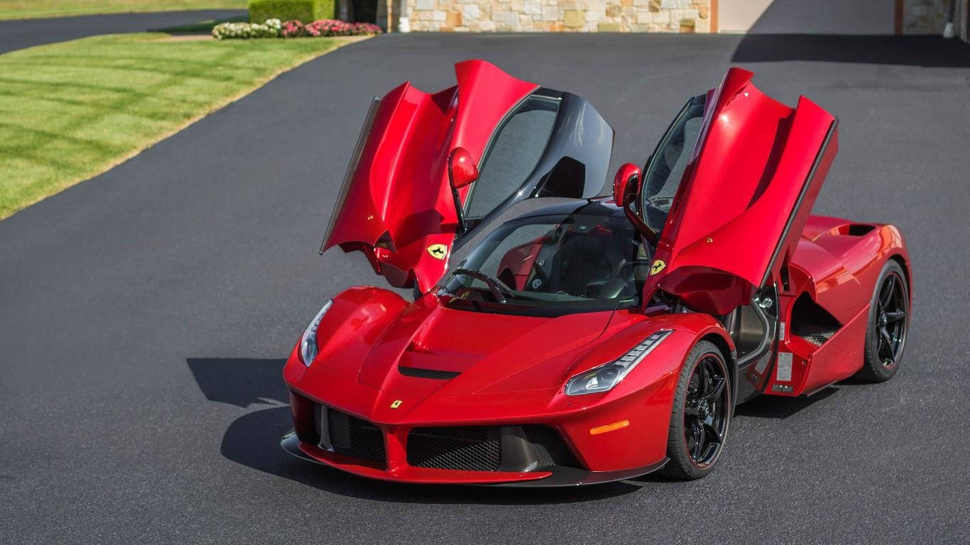 跑車 桌布 壁紙 — 一輛鮮紅色的法拉利LaFerrari，剪刀門打開，停在鋪砌的車道上，旁邊是修剪整齊的綠色草坪。