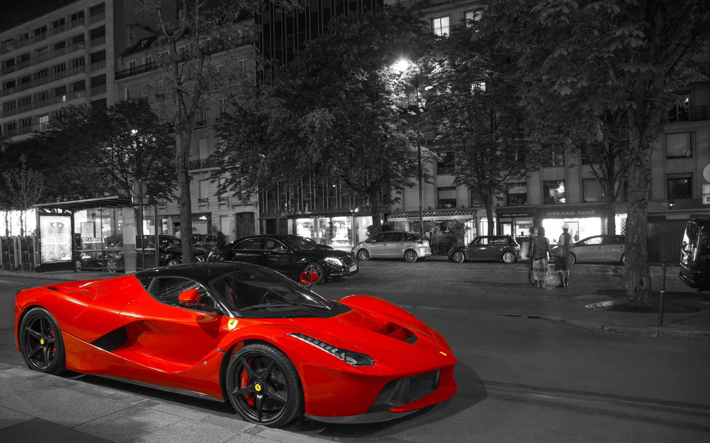 Ferrari Laferrari 桌布 壁紙 — 一輛鮮紅色的法拉利LaFerrari在夜晚停泊在城市的街道上，周圍是黑白環境。