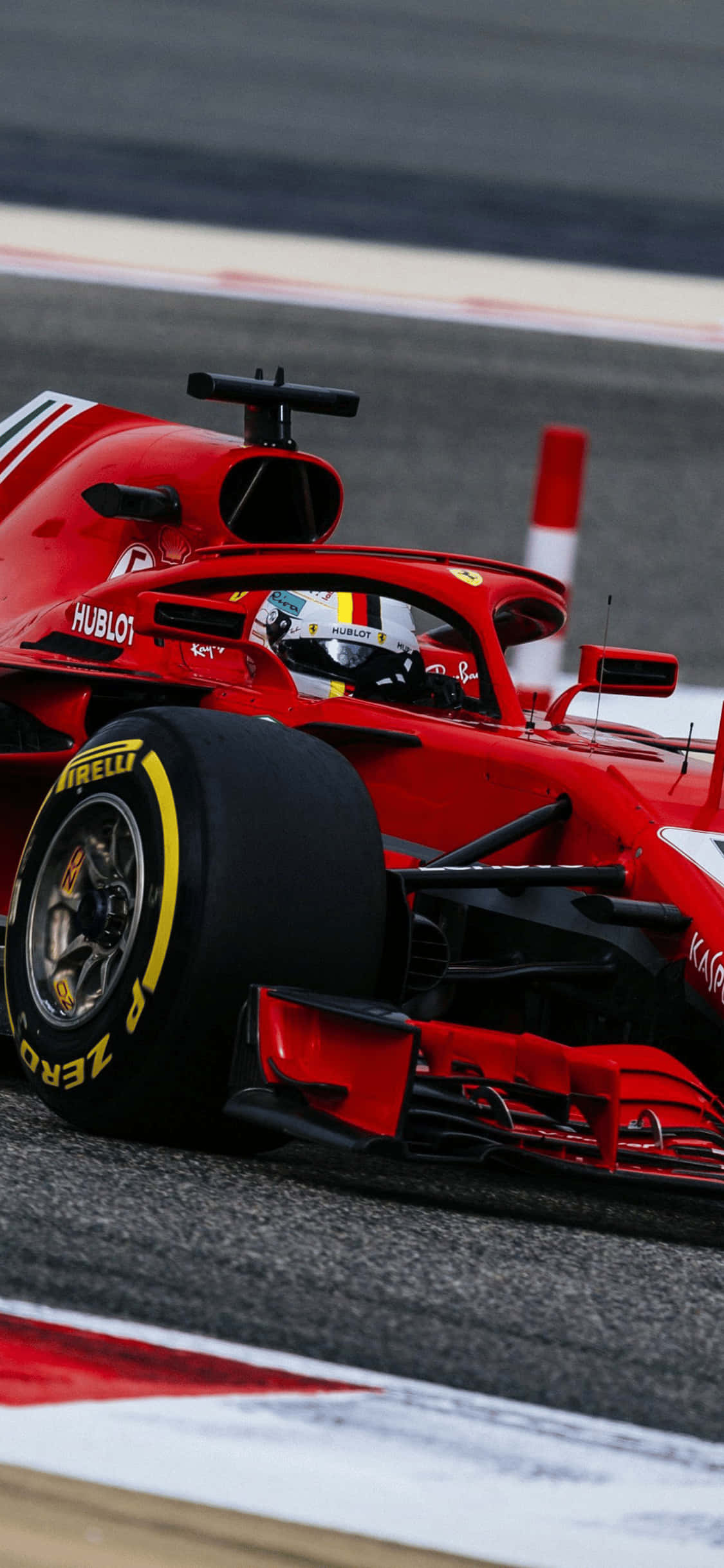 F1 2018 桌布 壁紙 — 一輛鮮紅色的法拉利一級方程式賽車在賽道上疾馳，駕駛艙內可見戴著頭盔的車手。