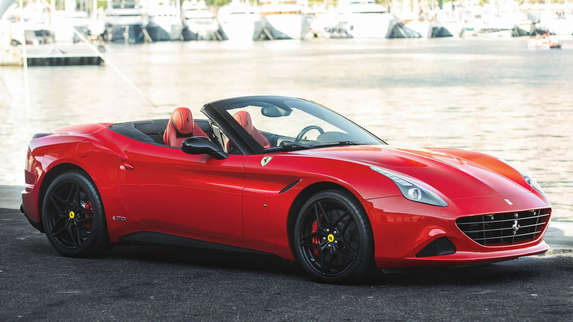 Ferrari California T 桌布 壁紙 — 一輛鮮紅色的法拉利敞篷車停泊在碼頭，背景有船隻。