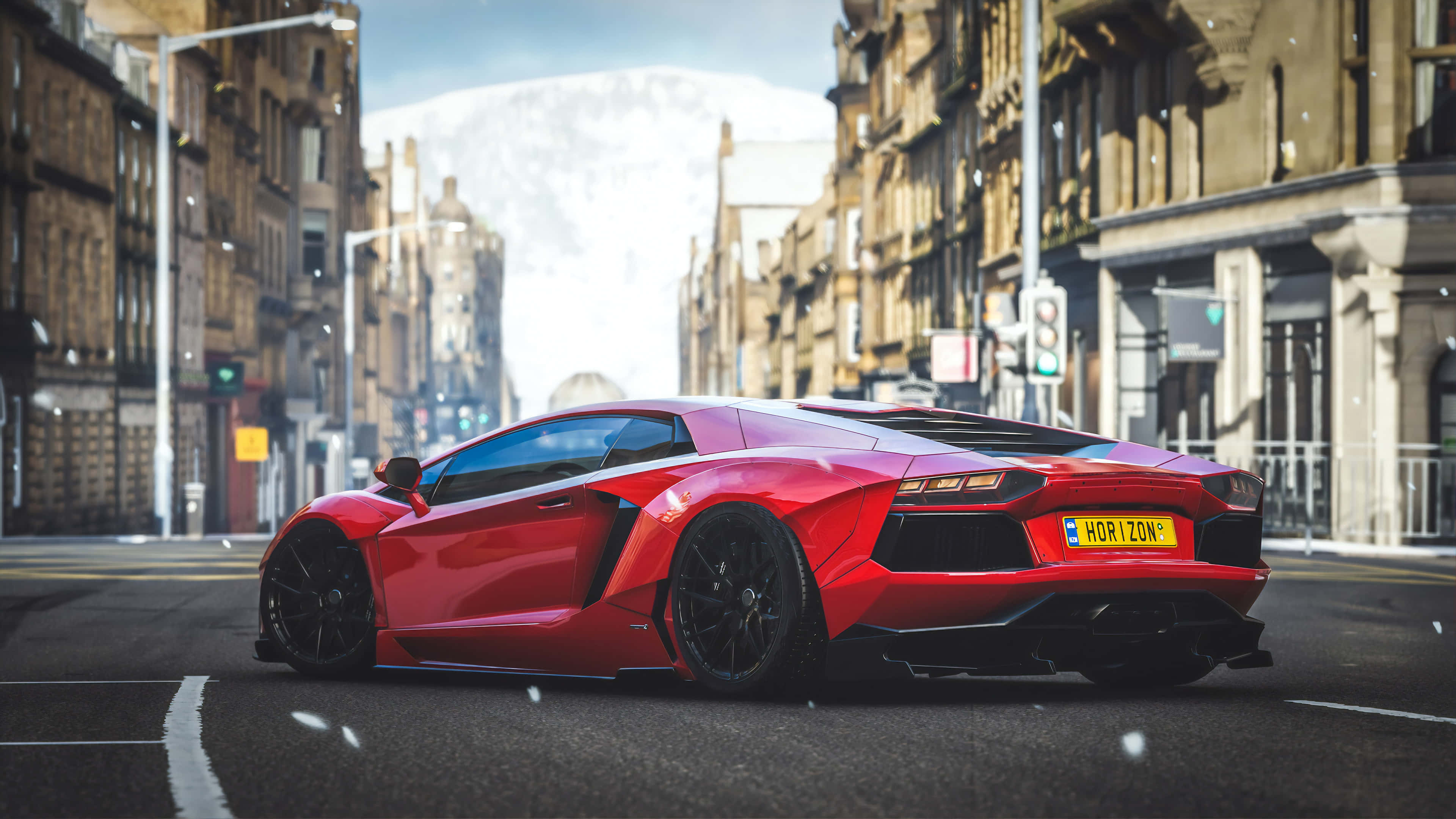 Forza Horizon 4 桌布 壁紙 — 一輛鮮紅色的藍寶堅尼Aventador在明亮的冬日天空下，沿著兩旁歷史悠久的石造建築物、積雪的城市街道奔馳。