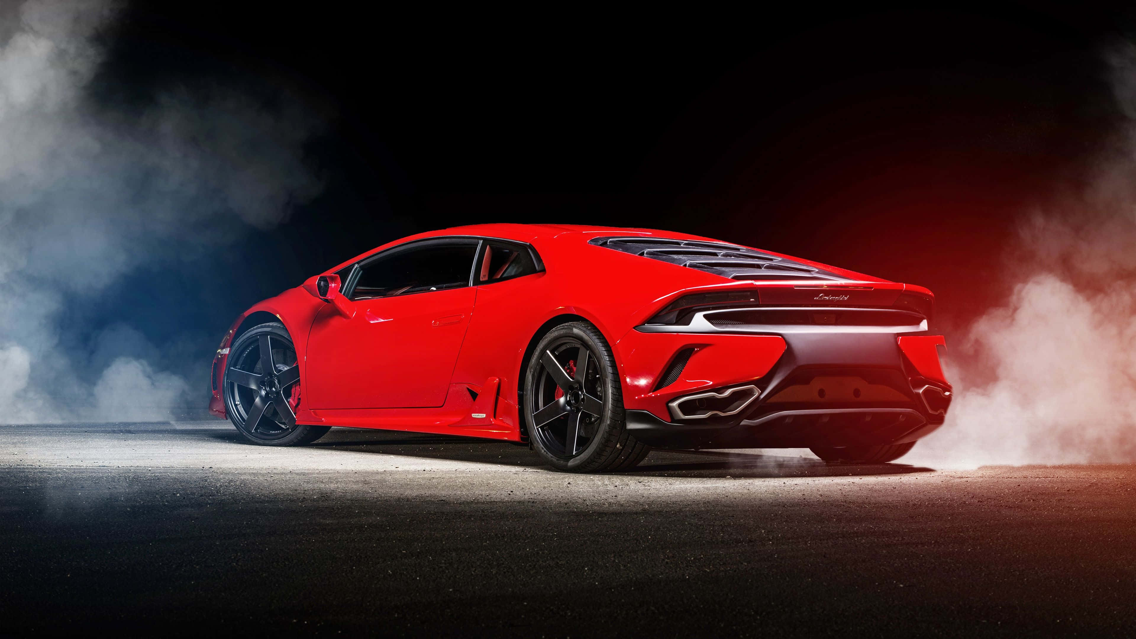 Car Design 桌布 壁紙 — 一輛鮮紅色的藍寶堅尼Huracán在戲劇性燈光下，於黑暗的瀝青賽道上冒煙飄移。