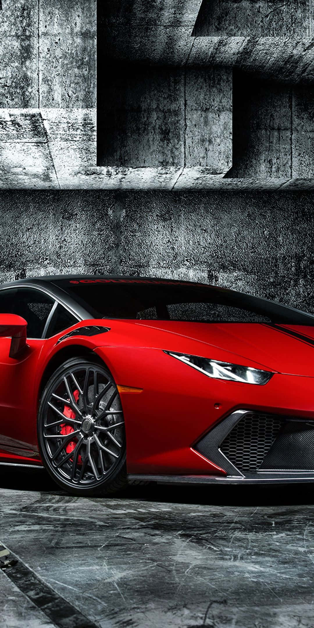 Pixel 3 Lamborghini 桌布 壁紙 — 一輛鮮紅色的藍寶堅尼跑車停泊在粗糙的混凝土天橋下，光線效果戲劇性。