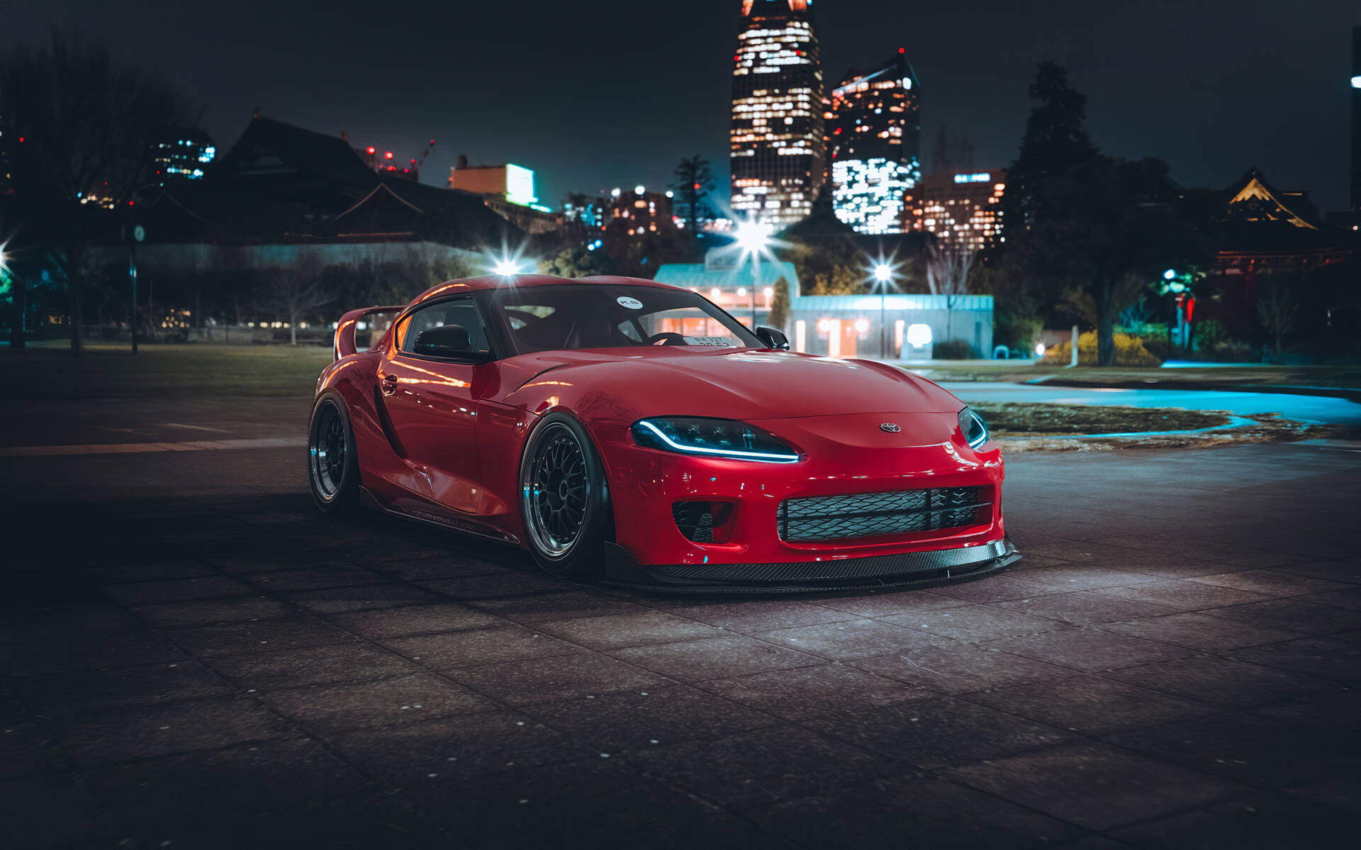 紅色跑車夜間停放，背景有城市燈光 — Toyota Supra Mk4 壁紙