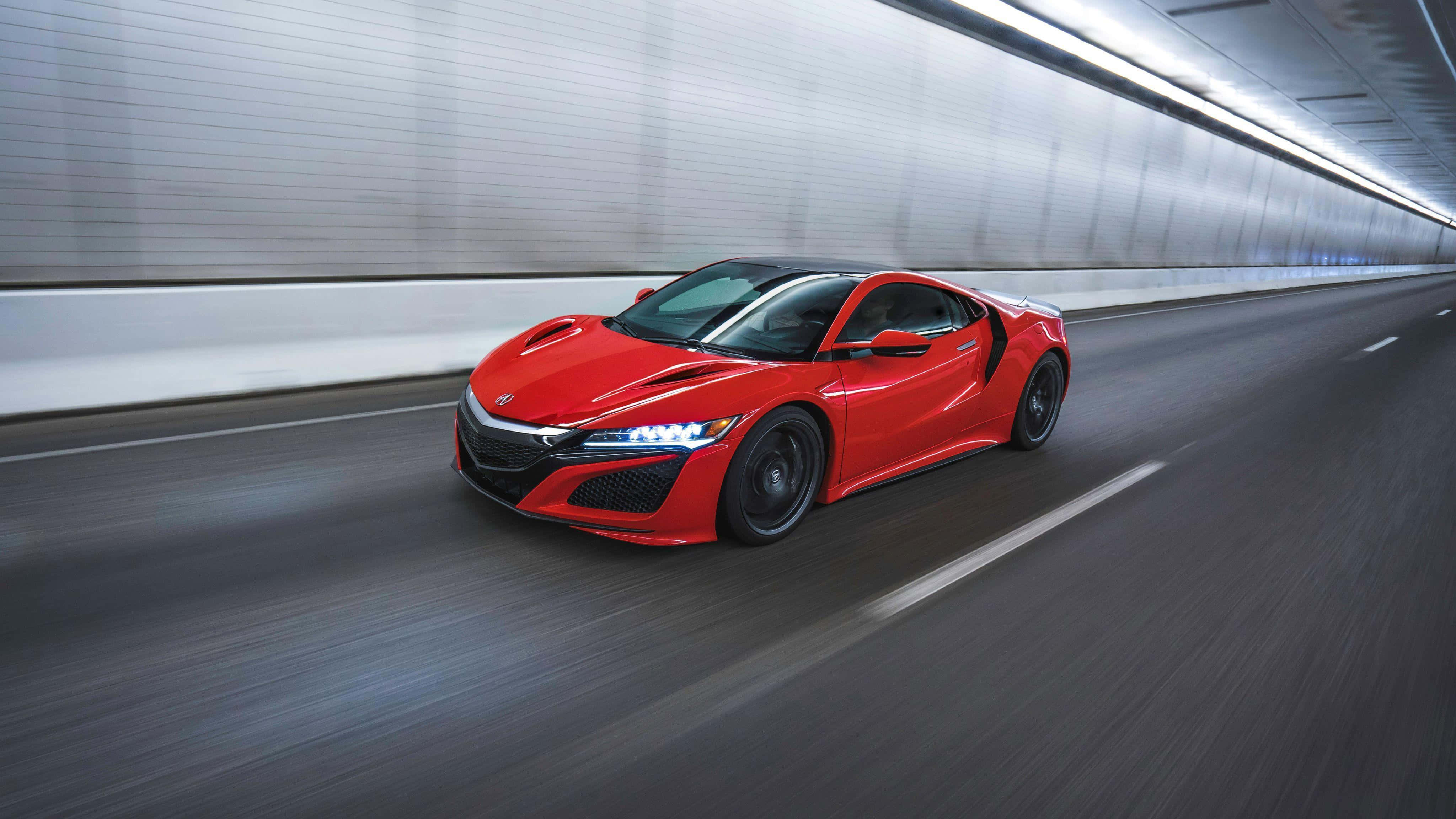 Acura Nsx 桌布 壁紙 — 一輛鮮紅色的跑車在時尚的隧道中疾馳，動態模糊效果強調了它的速度。