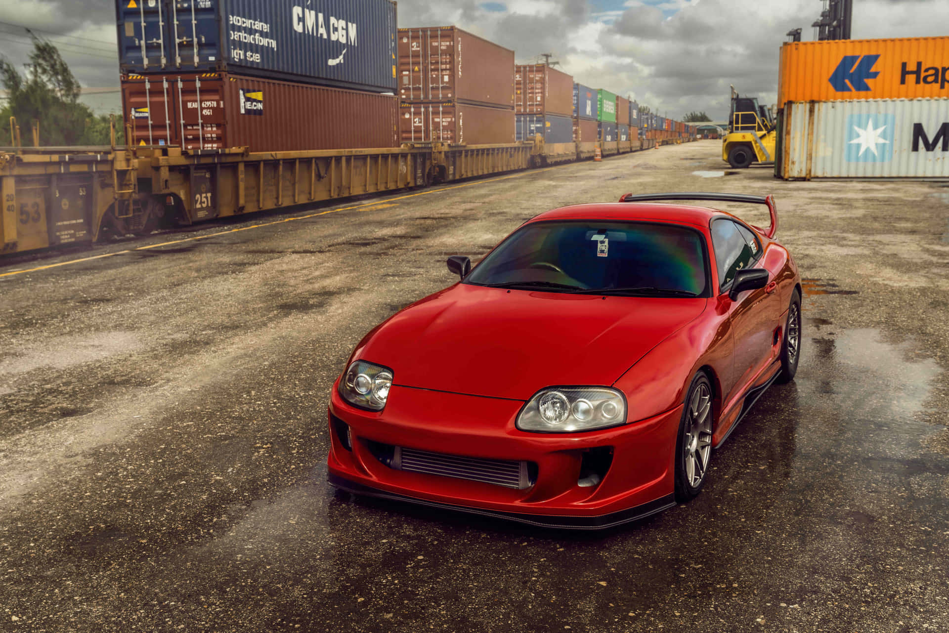 紅色跑車停在潮濕的工業貨運場。 — Toyota Supra Mk4 壁紙