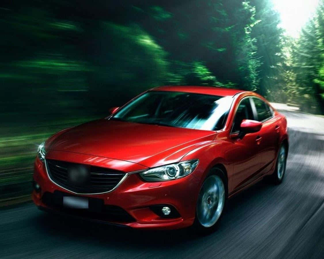 Mazda 6 桌布 壁紙 — 一輛鮮紅色的轎車在茂密的綠色森林中疾馳，動態模糊強調了其動態運動。