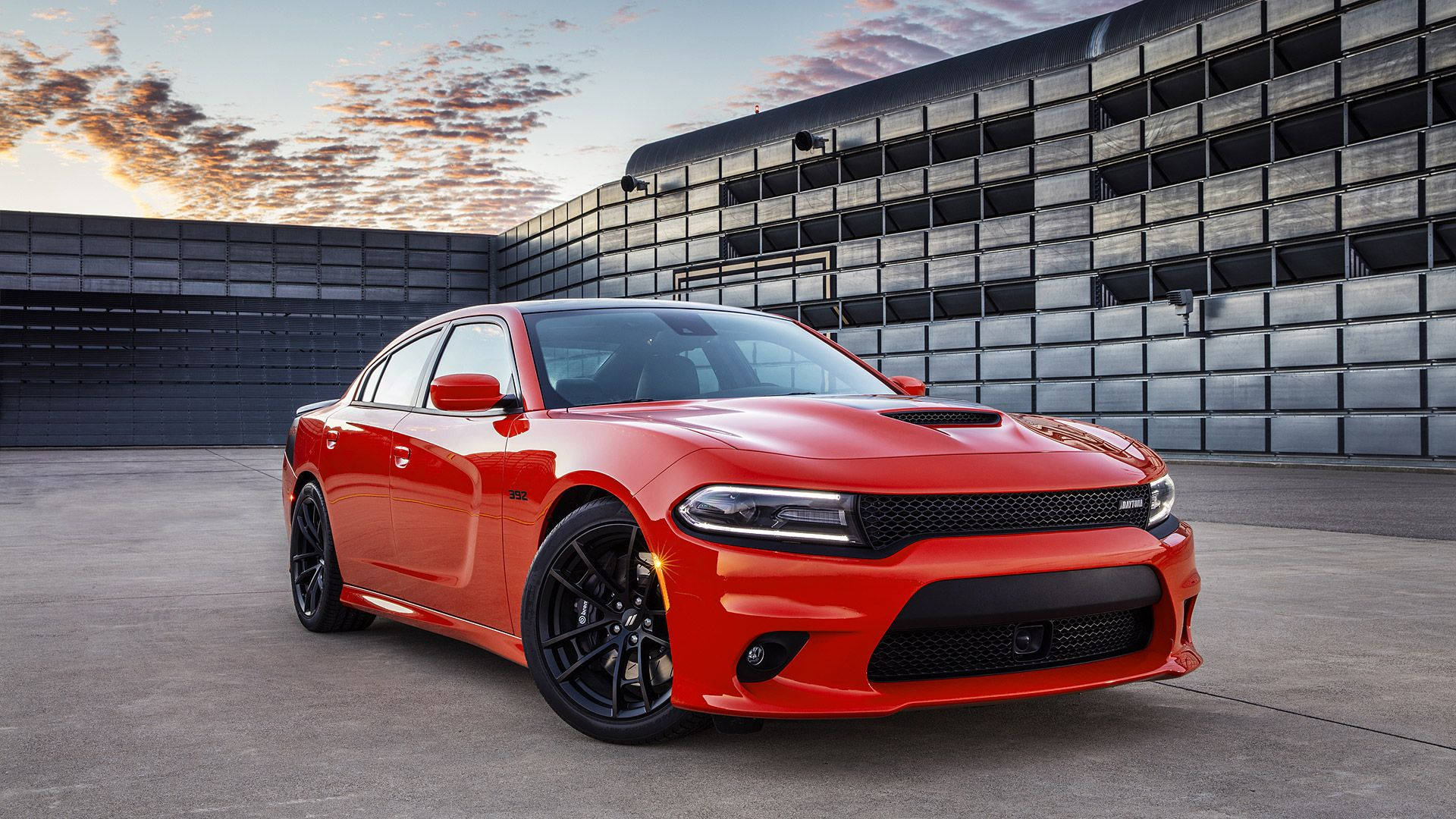 Dodge 桌布 壁紙 — 一輛鮮紅色的道奇 Charger SRT Hellcat 在日落時分停在一棟現代工業建築前。
