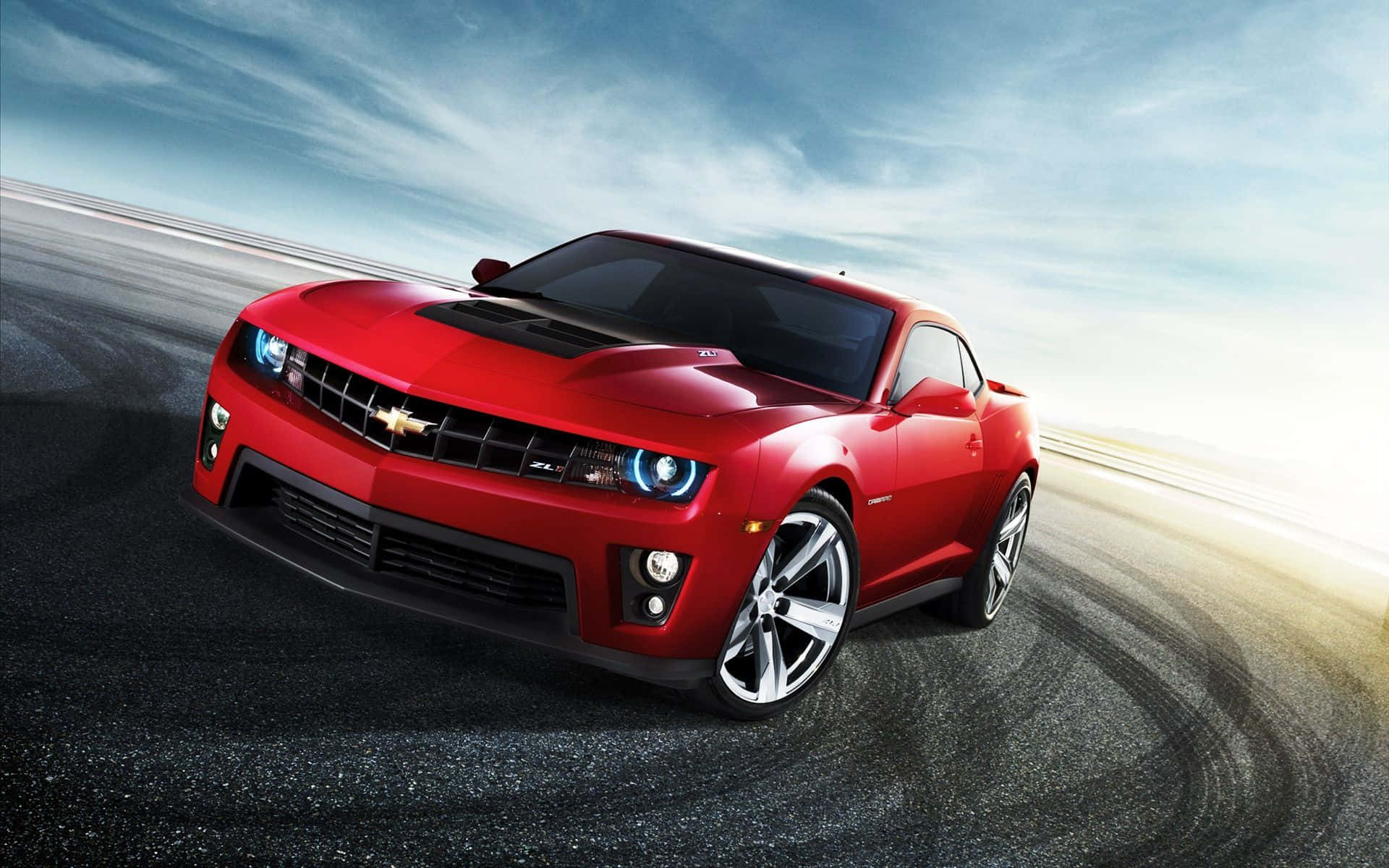 Chevrolet 桌布 壁紙 — 一輛鮮紅色的雪佛蘭Camaro ZL1在動態天空下，沿著濕滑賽道疾馳，帶有動態模糊效果。