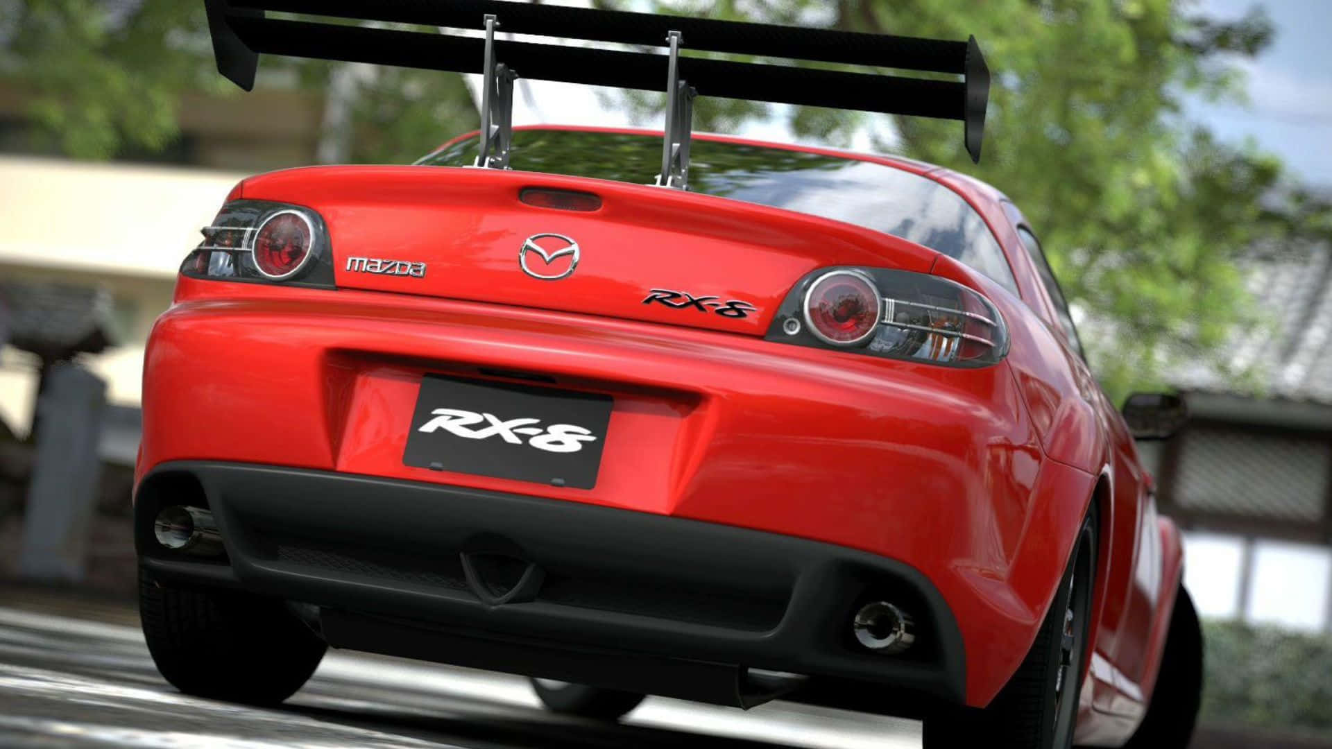 Mazda Rx-8 桌布 壁紙 — 一輛鮮紅色的馬自達RX-8跑車，帶有大型後擾流板，從後方拍攝，背景是綠樹成蔭的道路。