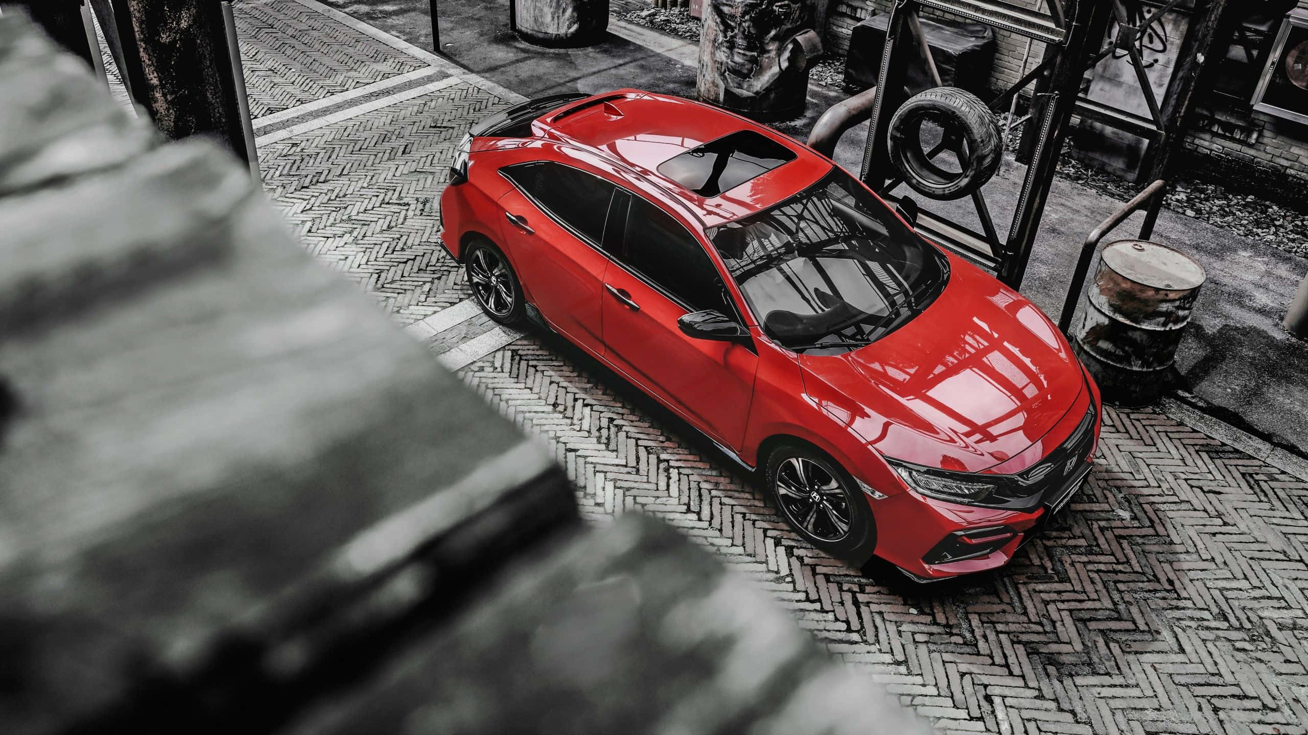 Hatchback 桌布 壁紙 — 一輛鮮紅色跑車停放在粗糙工業車庫的人字形圖案路面上。