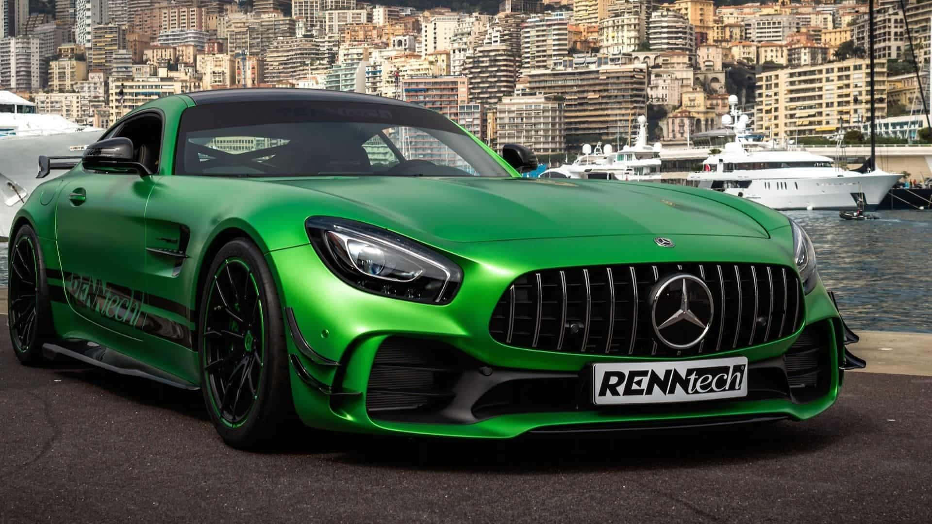 汽車 桌布 壁紙 — 一輛鮮綠色、經RENNtech改裝的Mercedes-AMG GT停泊在港口，背景是豪華遊艇和密集的沿海城市景觀。