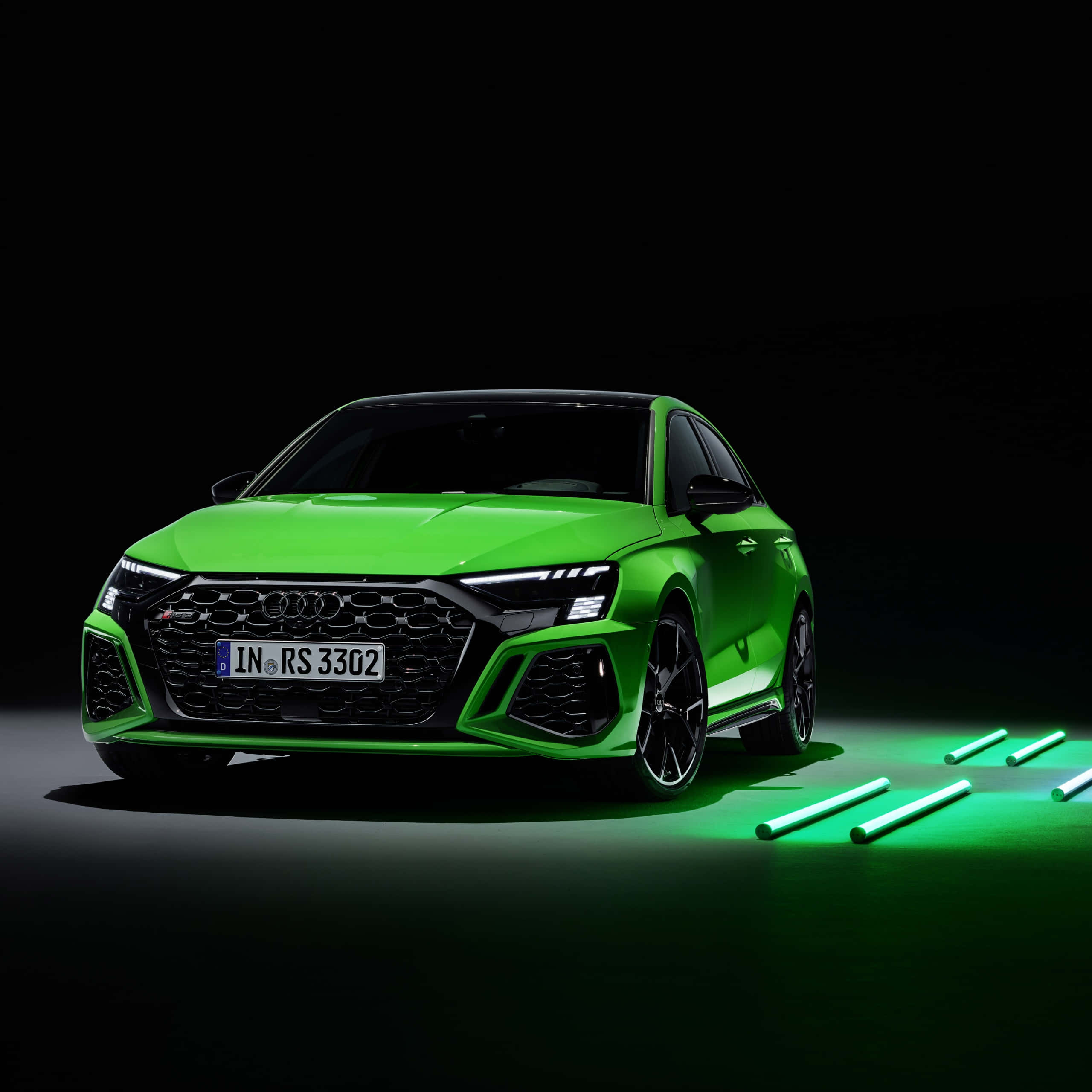奧迪 桌布 壁紙 — 一輛鮮綠色的Audi RS3 Sportback在黑色背景和發光綠色管的地板上，於攝影棚燈光下閃閃發光。