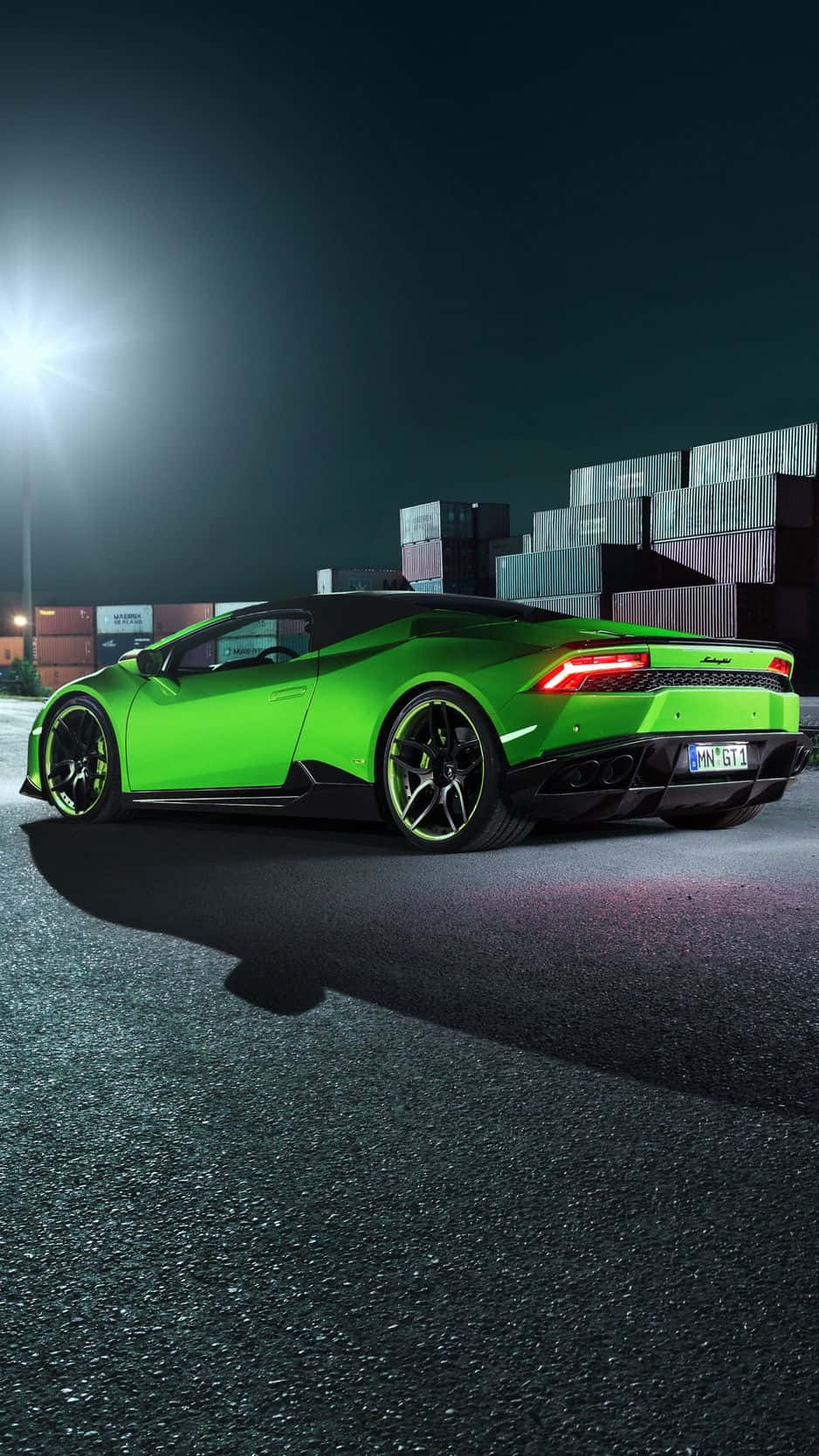 主題 桌布 壁紙 — 一輛鮮綠色藍寶堅尼Huracán LP 610-4在夜間堆疊的貨運集裝箱前，在明亮的聚光燈下閃耀。