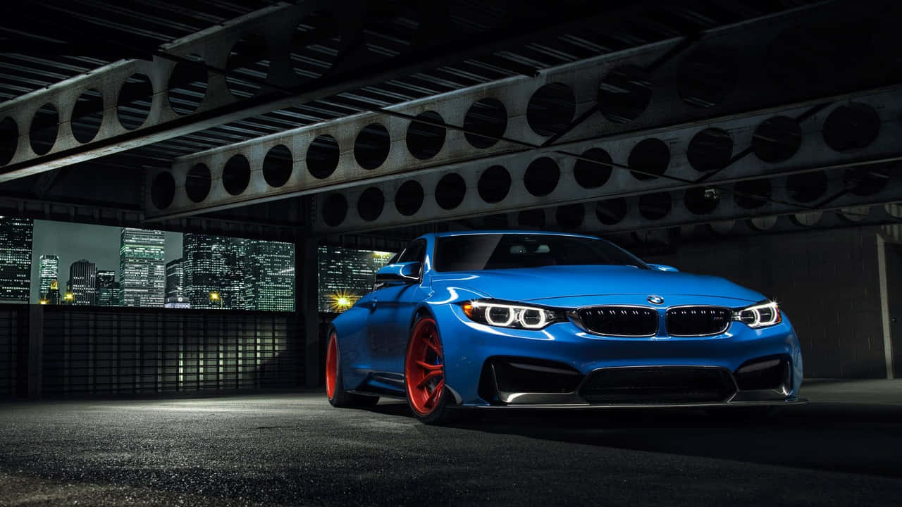 720p Bmw 桌布 壁紙 — 一輛鮮藍色BMW跑車配紅色輪圈，夜晚停泊在鋼橋下，背景城市燈光閃爍。