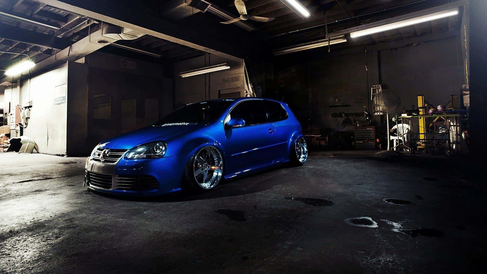 Tuned Car 桌布 壁紙 — 一輛鮮藍色改裝福斯Golf在螢光燈下低趴於昏暗的車庫中。