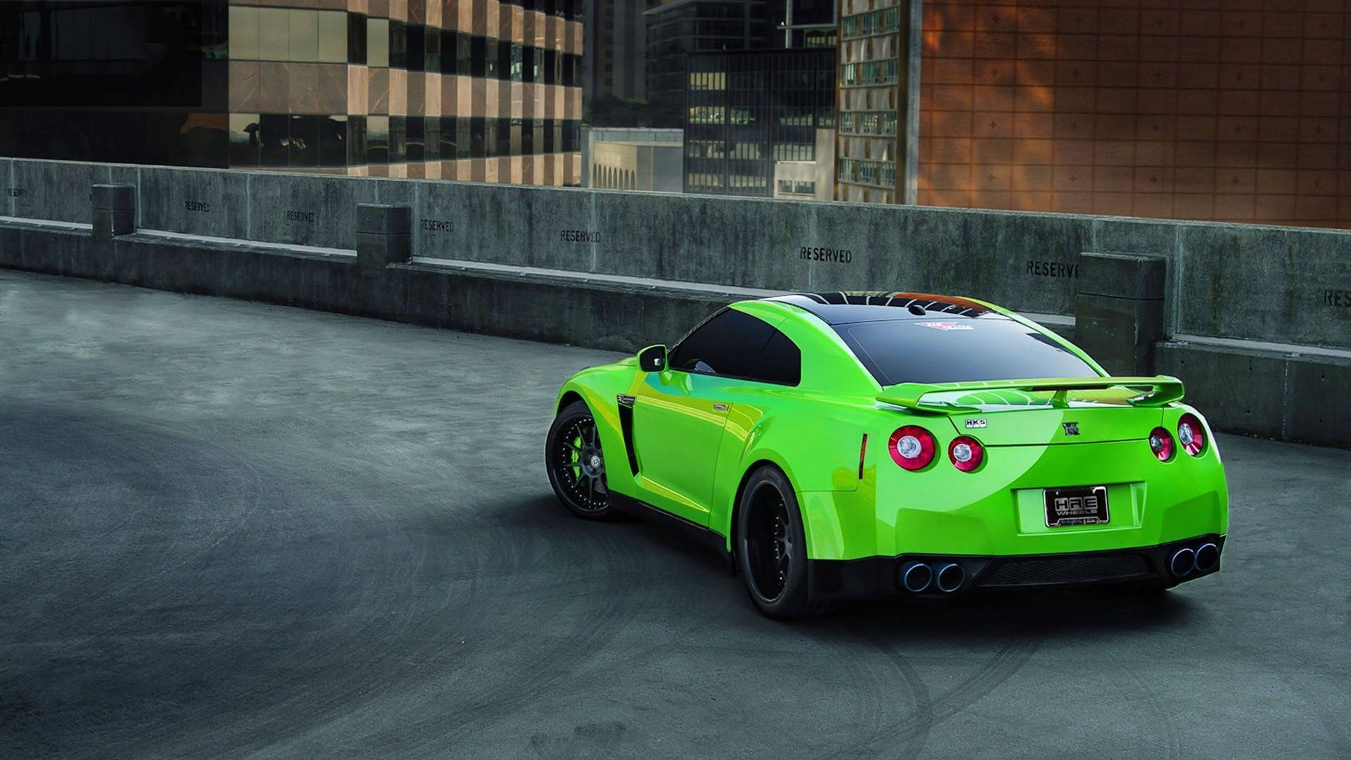 Nissan 桌布 壁紙 — 一輛鮮豔的青檸綠色日產GT-R跑車停放在混凝土城市屋頂，背景有現代建築。