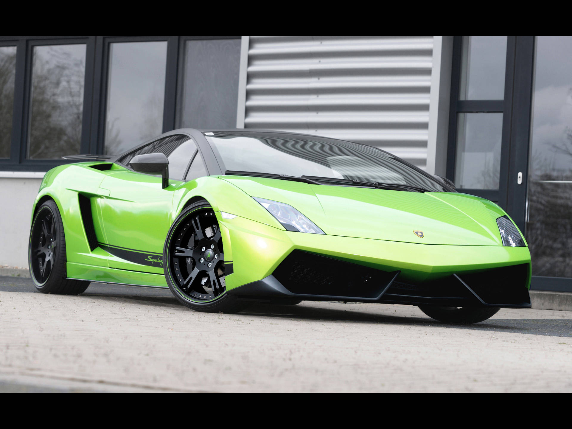 4K Lamborghini 桌布 壁紙 — 一輛鮮豔的青檸綠色藍寶堅尼Gallardo跑車停放在一棟有大窗戶的現代建築前。